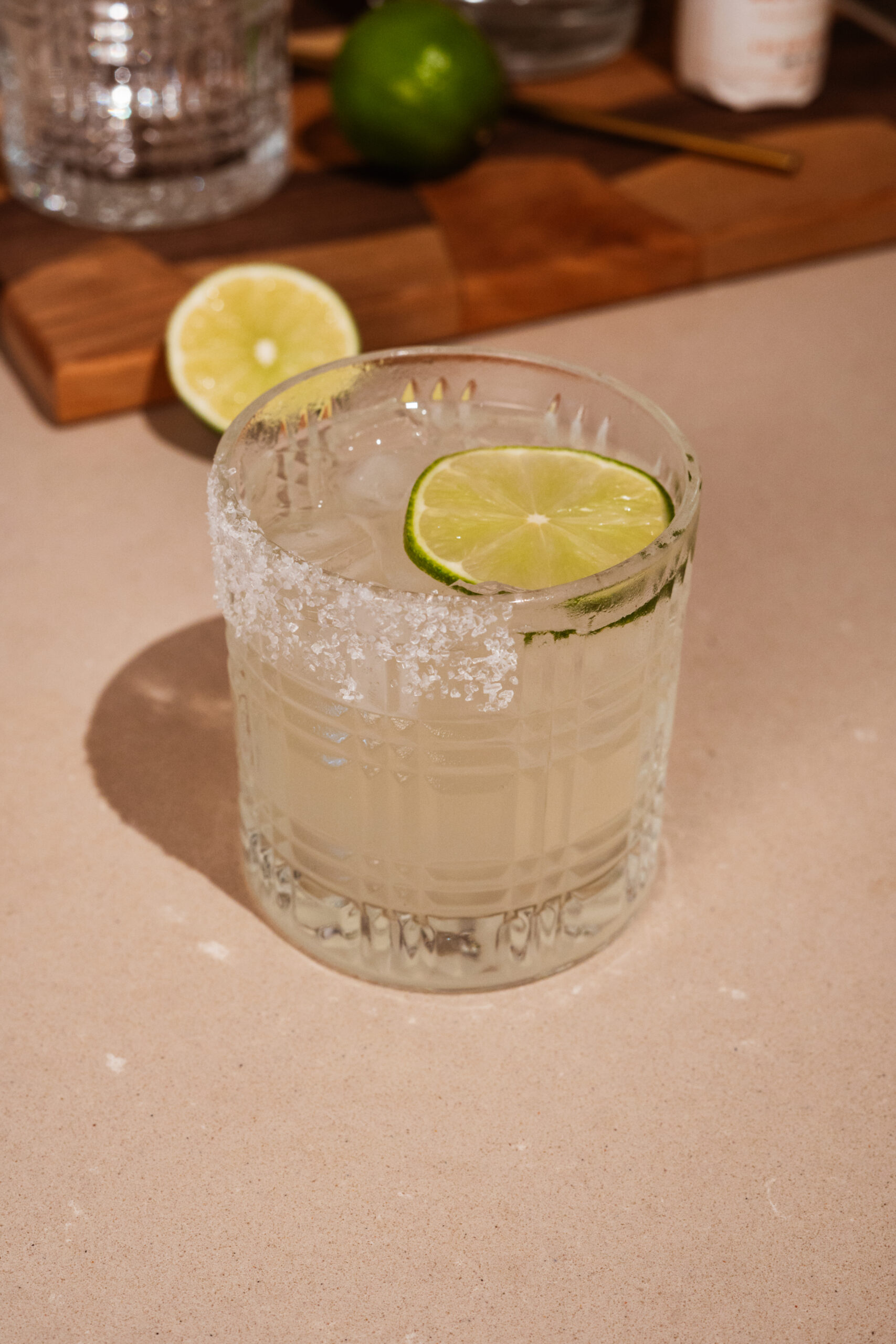 tequila lemonade in rocks glass garnished with salt and lime.