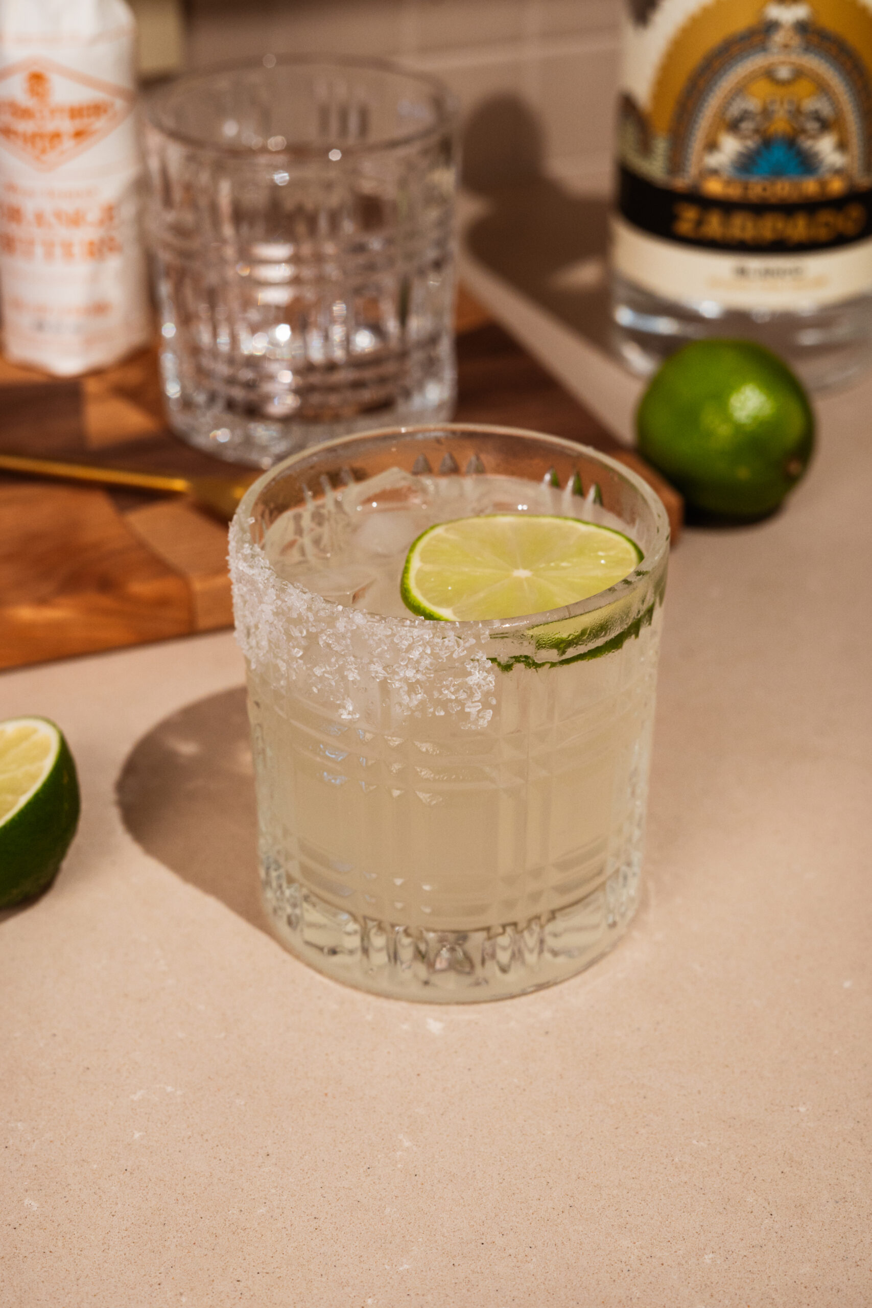 tequila lemonade in rocks glass garnished with salt and lime.