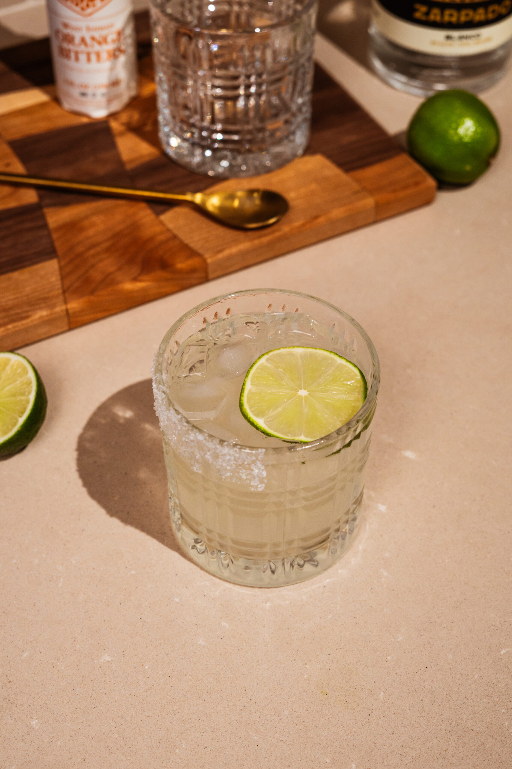 overhead view of tequila lemonade in rocks glass garnished with salt and lime.