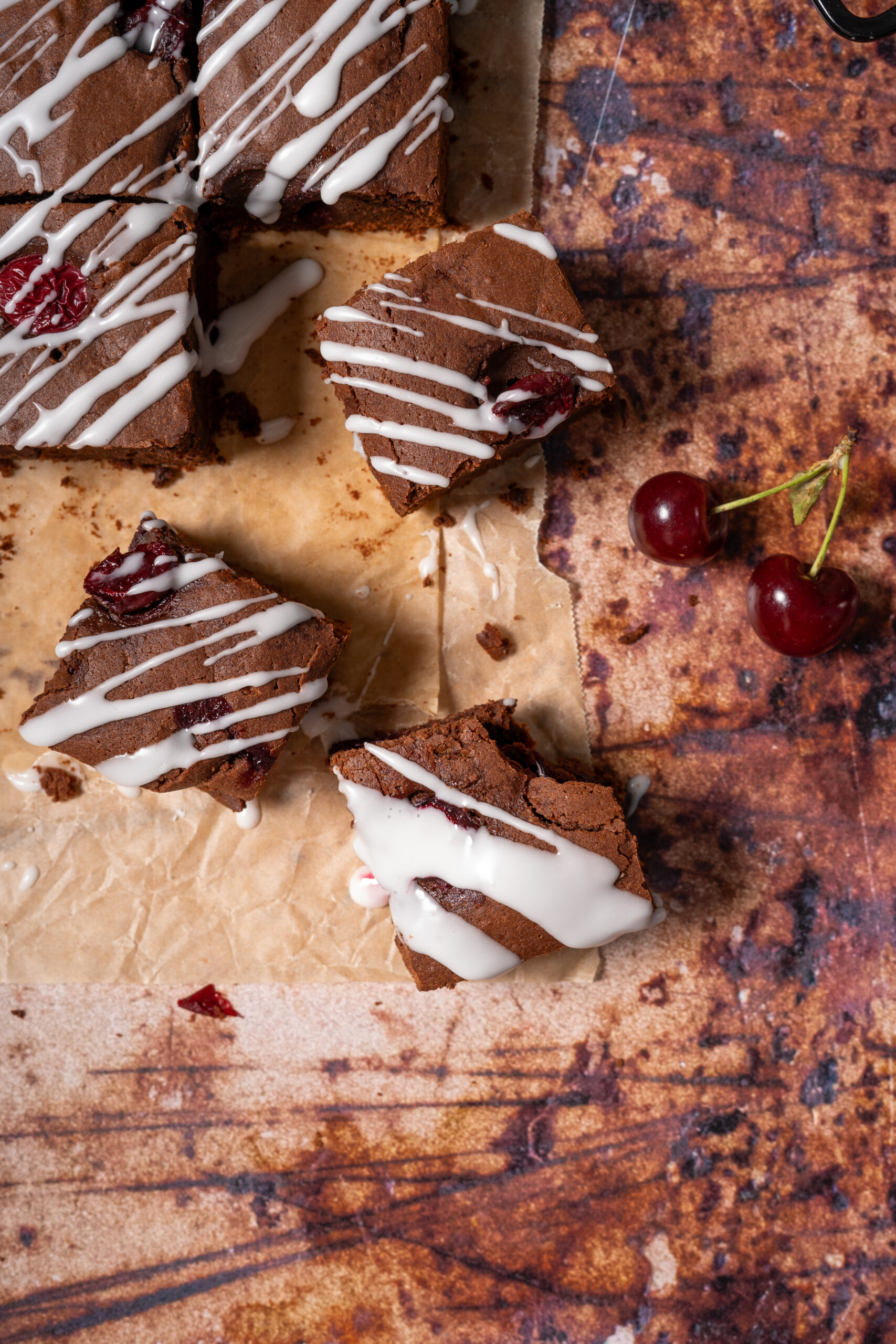 chocolate cherry brownies scattered on parchment paper.