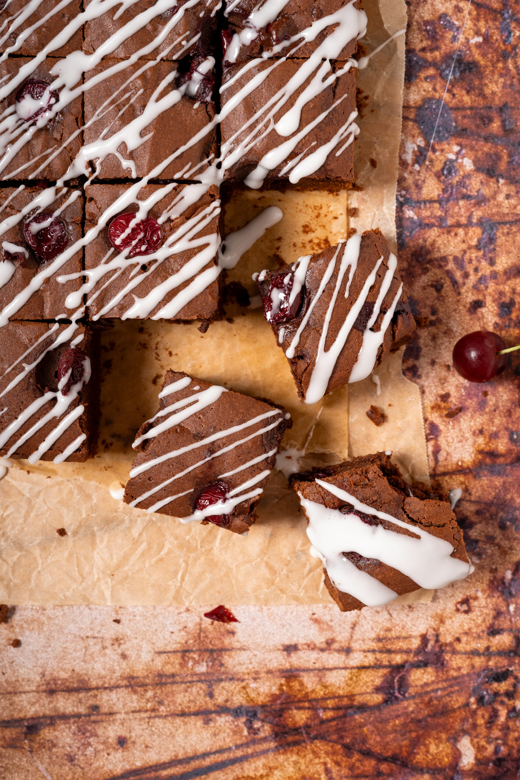 chocolate cherry brownies scattered on parchment paper.