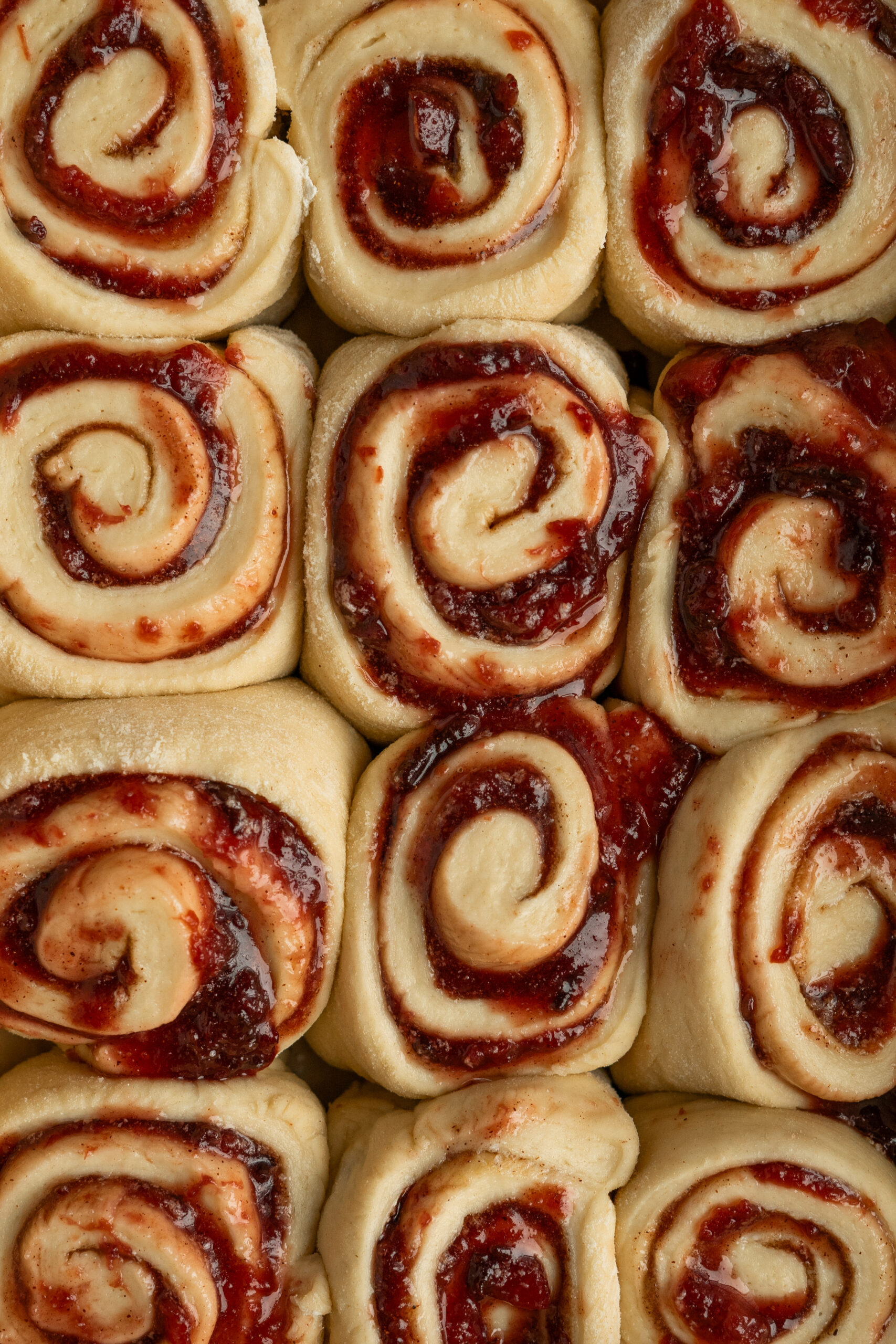 overhead closeup of unfrosted plum cinnamon rolls.