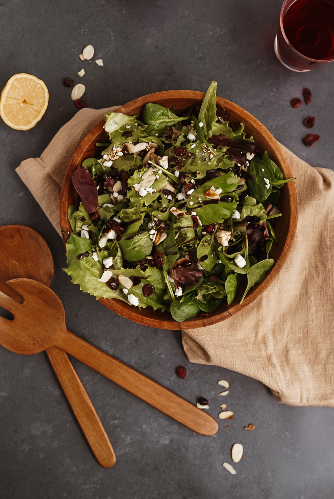 cranberry goat cheese salad in wooden bowl on black background.