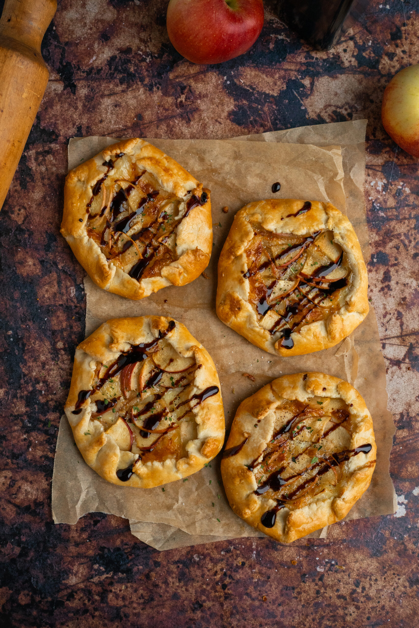 mini brie and apple galettes on parchment paper.