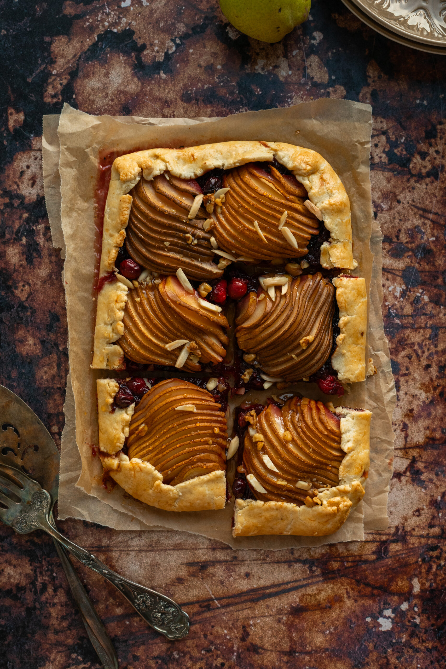 overhead view of sliced cranberry pear galette on parchment paper.