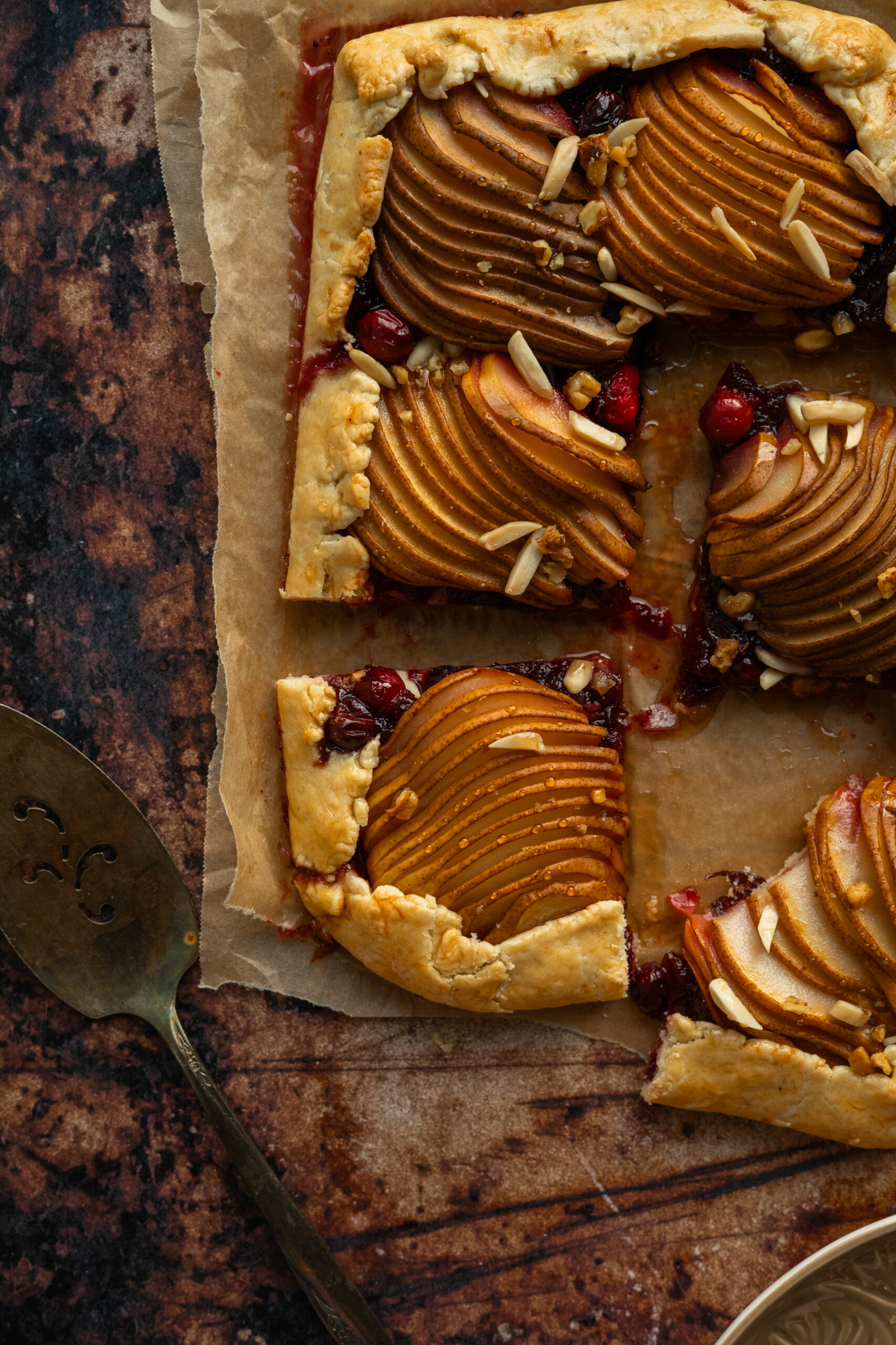 close up of sliced cranberry pear galette on parchment paper.