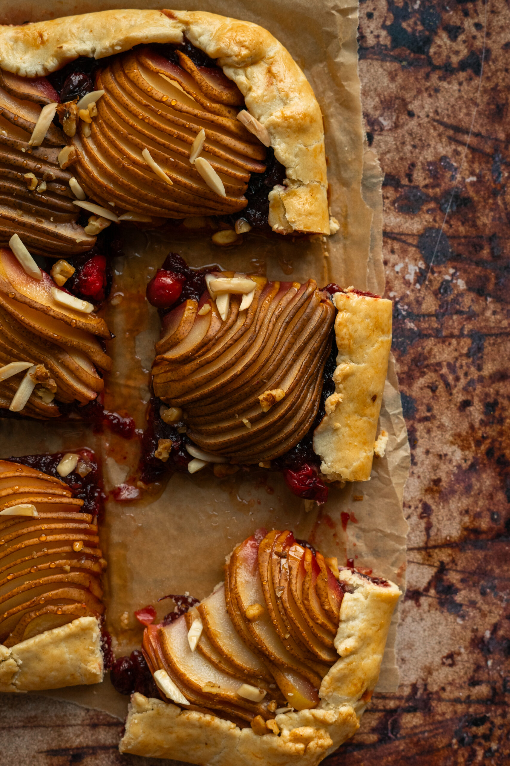 close up of sliced cranberry pear galette on parchment paper.