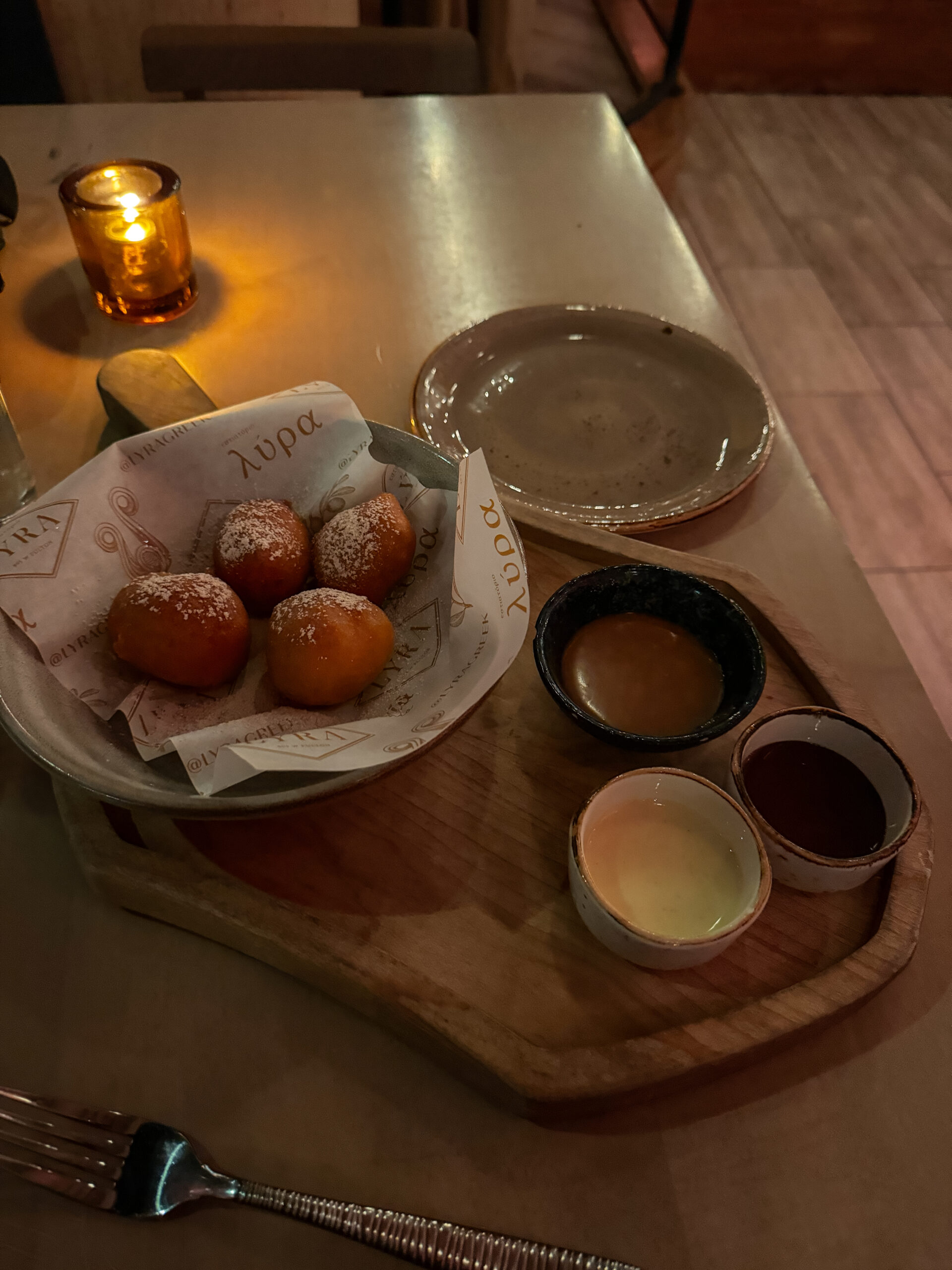 wooden tray with donuts and sauces.