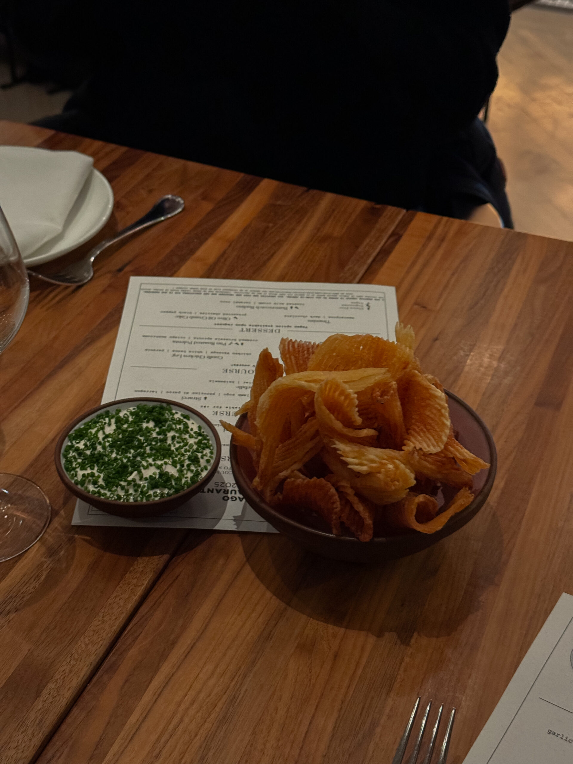 chips and onion dip on wooden table.