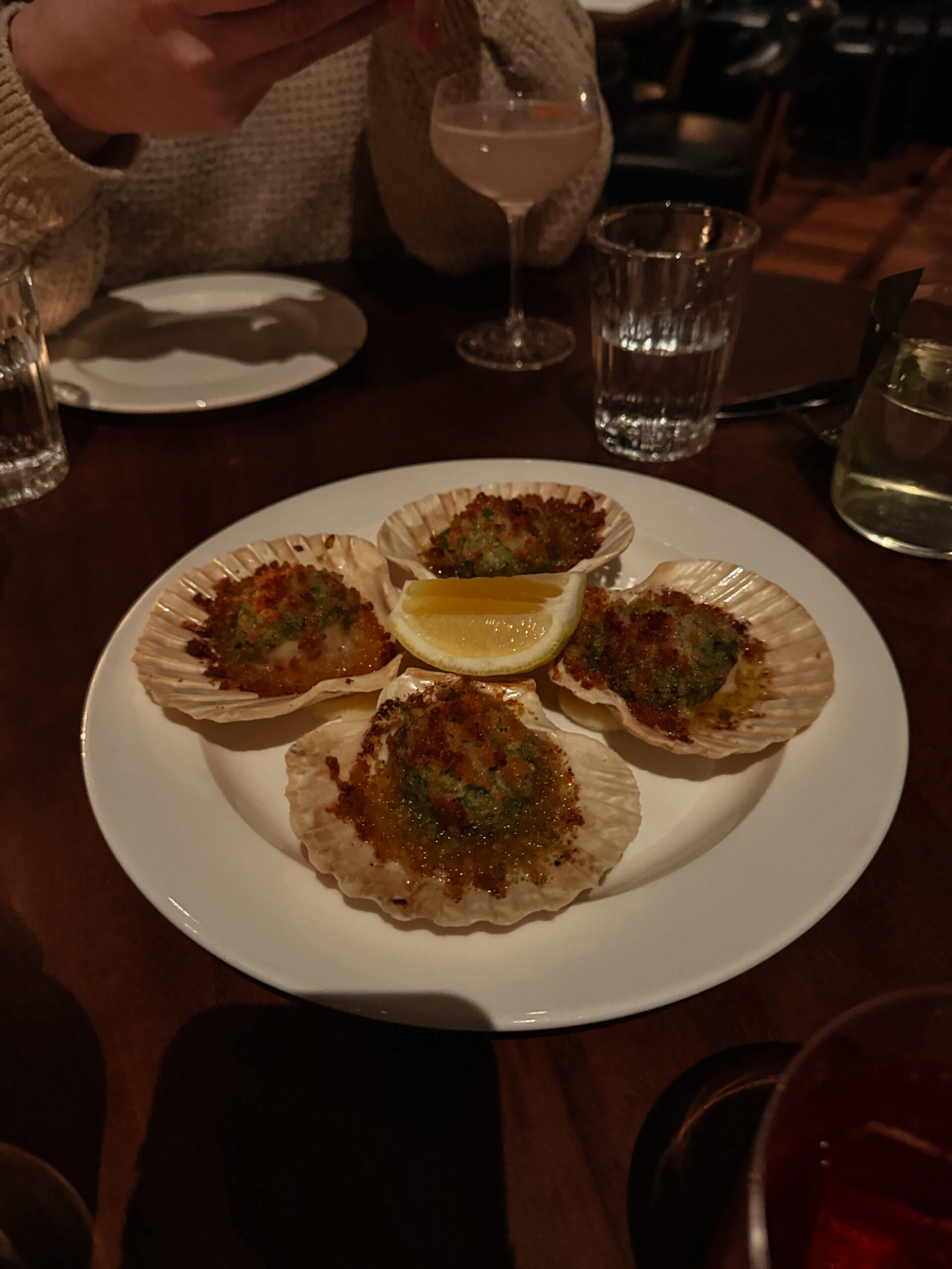 scallops on seashells on white plate.