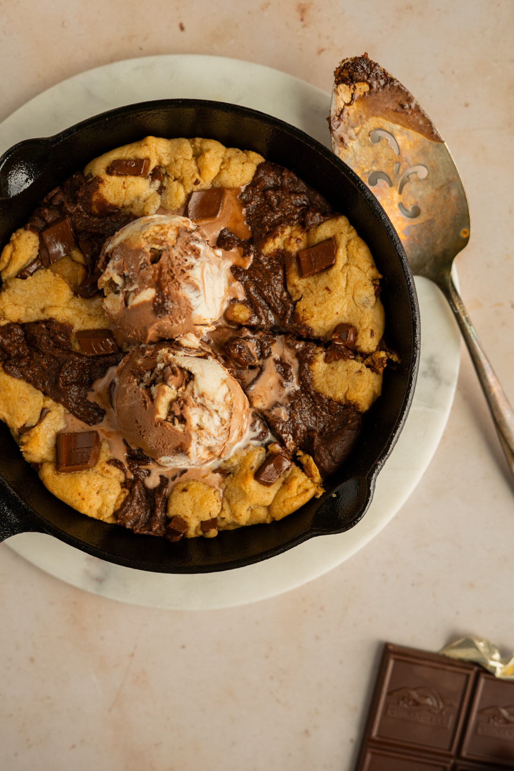 brownie skillet cookie with ice cream on top and slice taken out of the side.