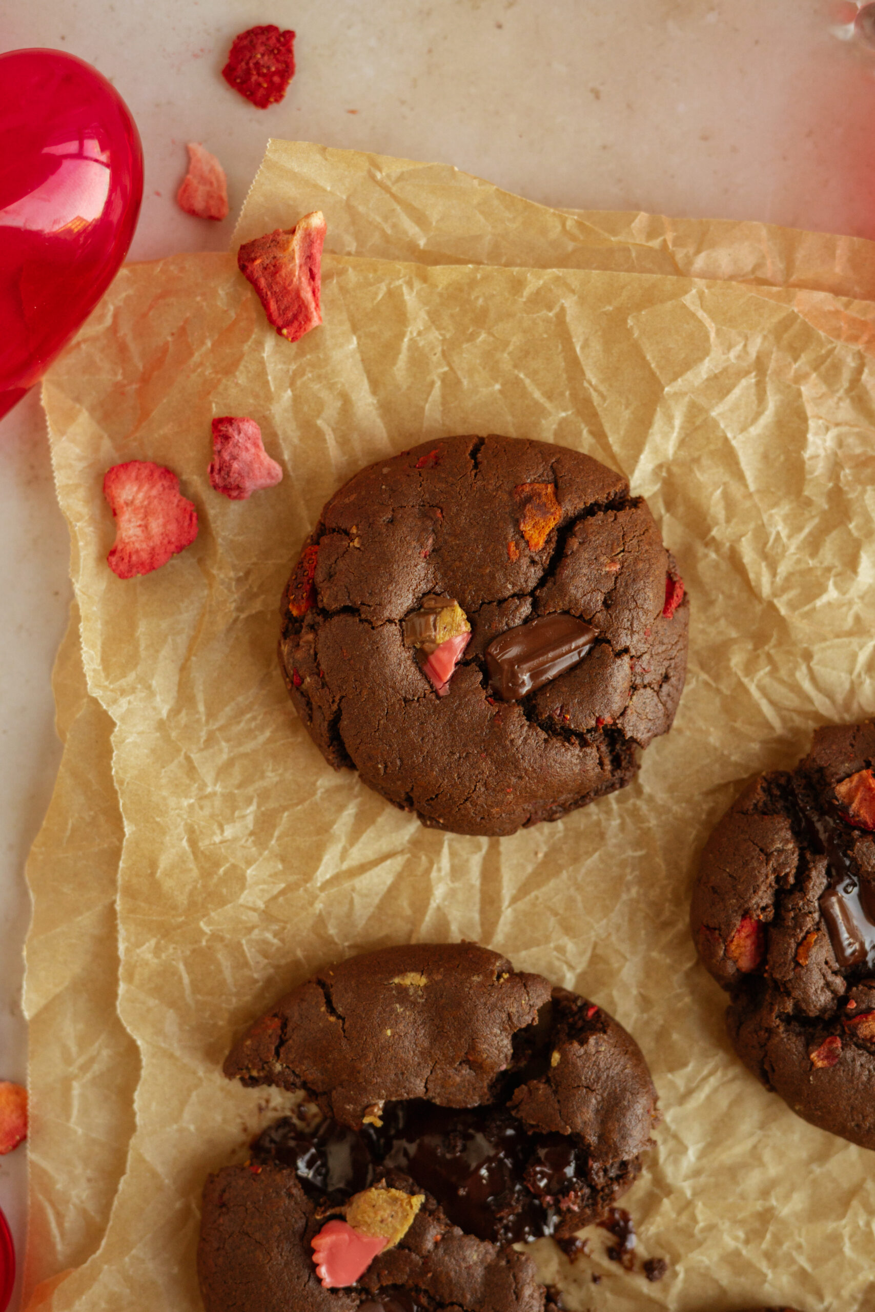 close up of one chocolate covered strawberry cookie on parchment paper.