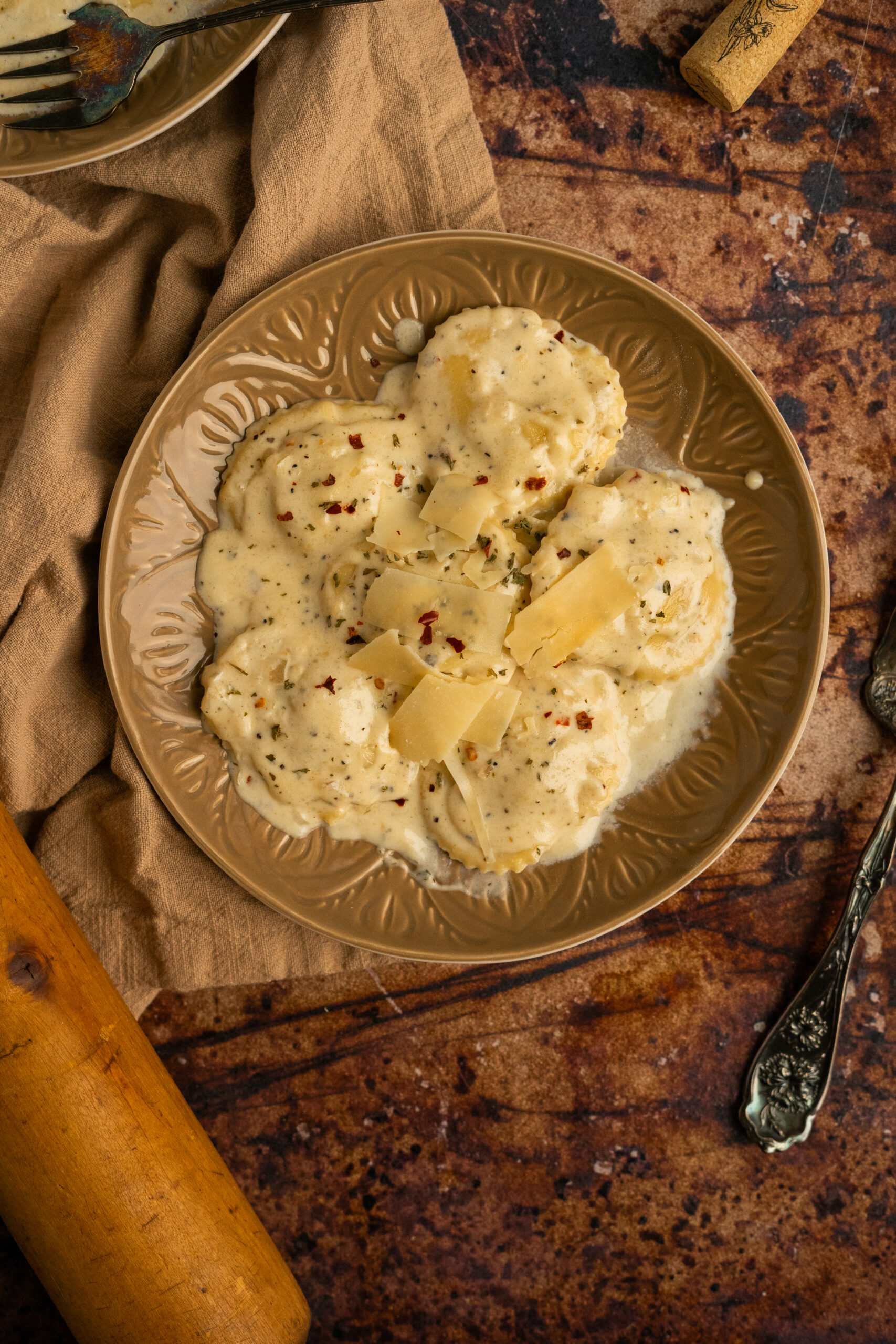 ravioli in white wine sauce on brown plate.