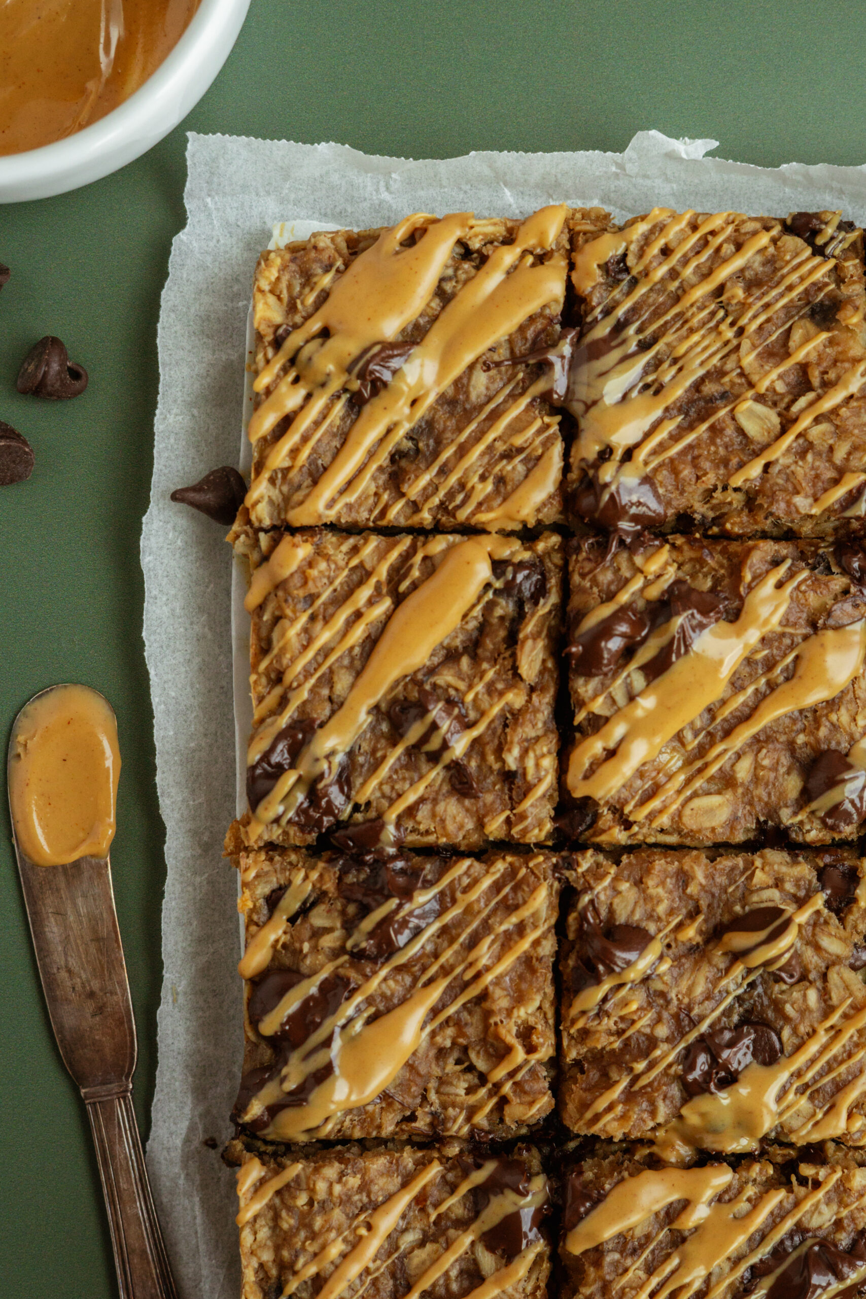 banana oat bars sliced into squares with a spread of peanut butter to the side.