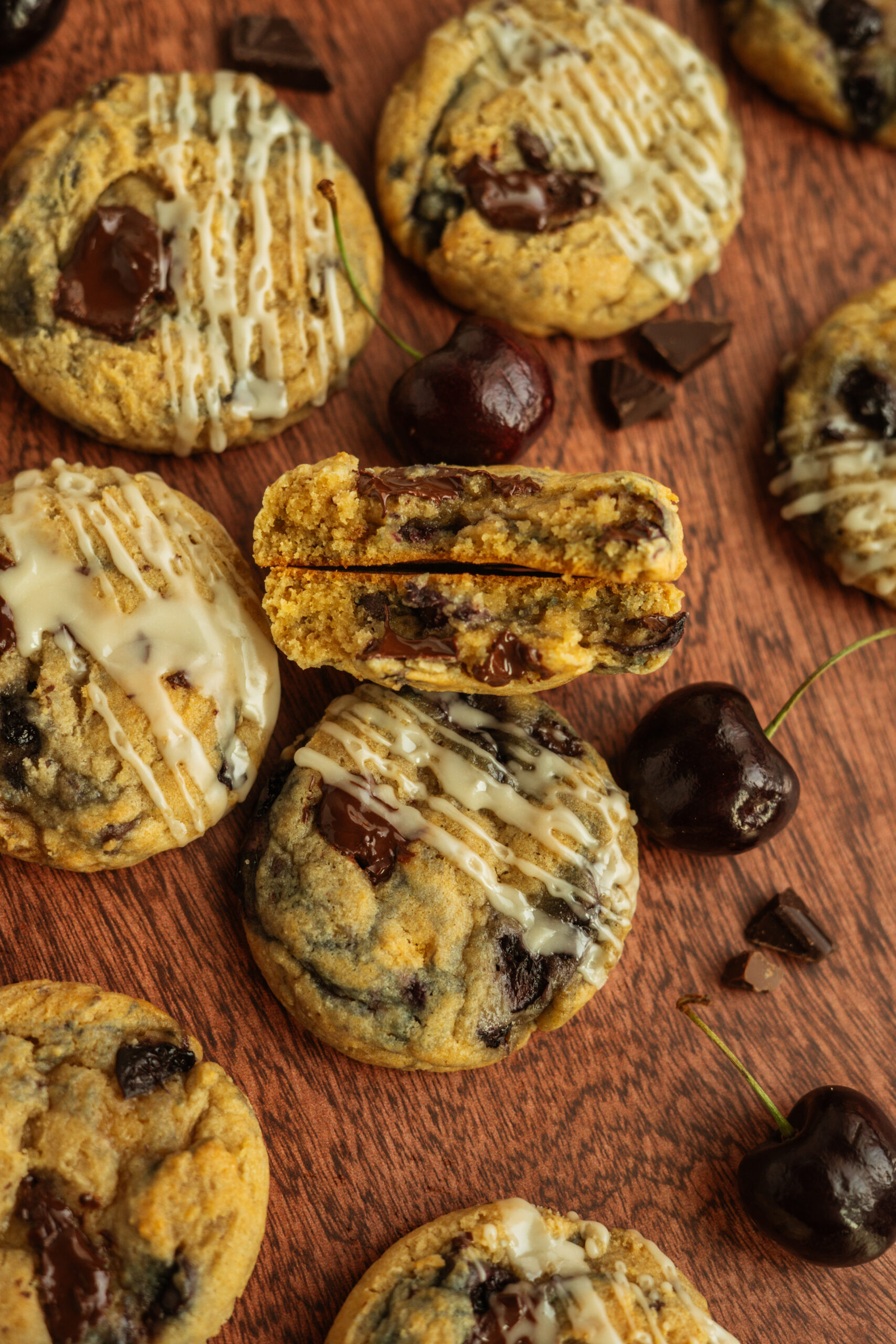cross section of chocolate cherry cookie cut in half, surrounded by other cookies.