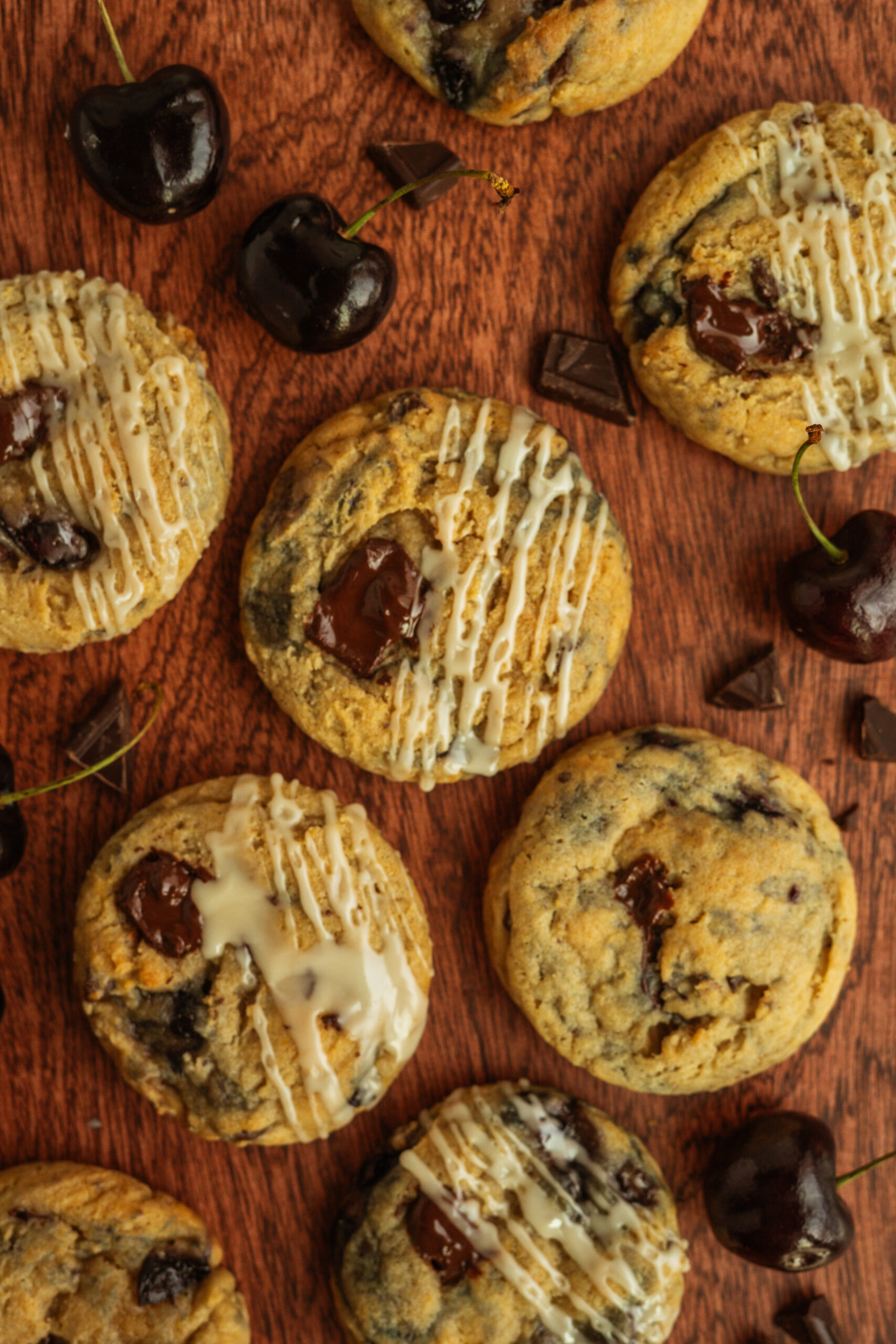 overhead view of chocolate cherry cookies on wooden surface.