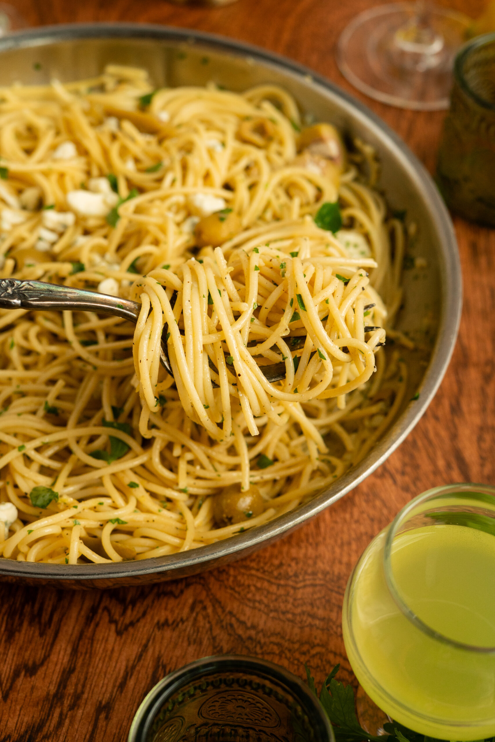 forkful of dirty martini pasta take out of large steel pan.