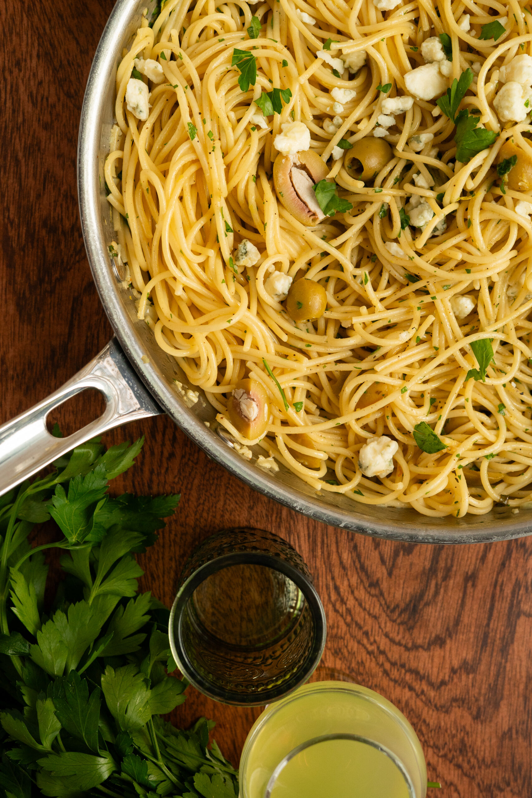 close up of dirty martini pasta in large steel pan.