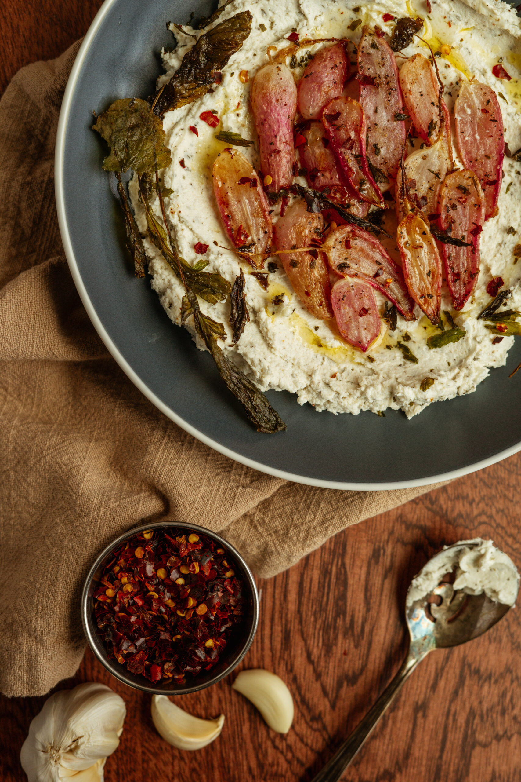 goat cheese with roasted radishes in blue bowl.