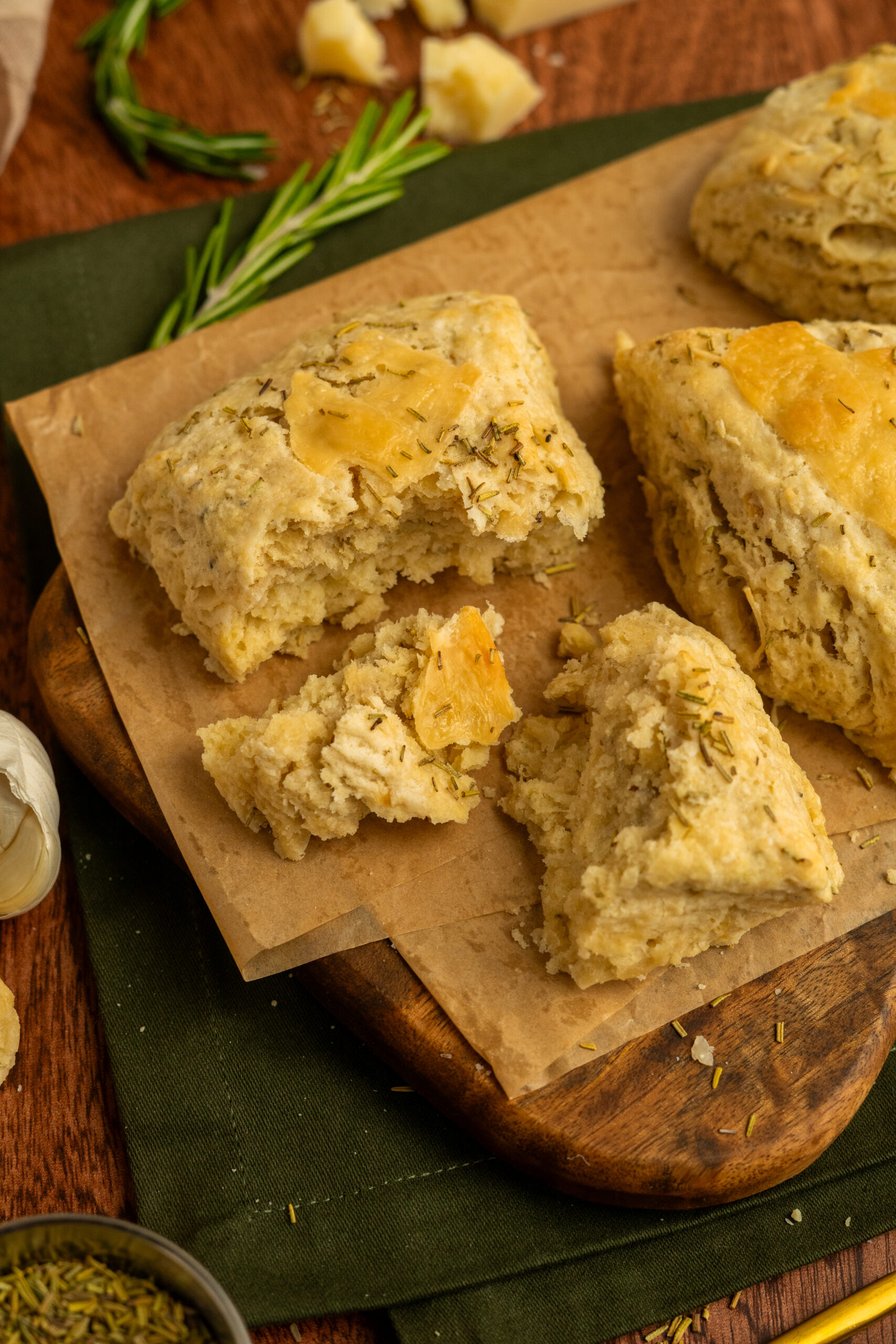 close up of parmesan garlic scones broken on a wooden cutting board.