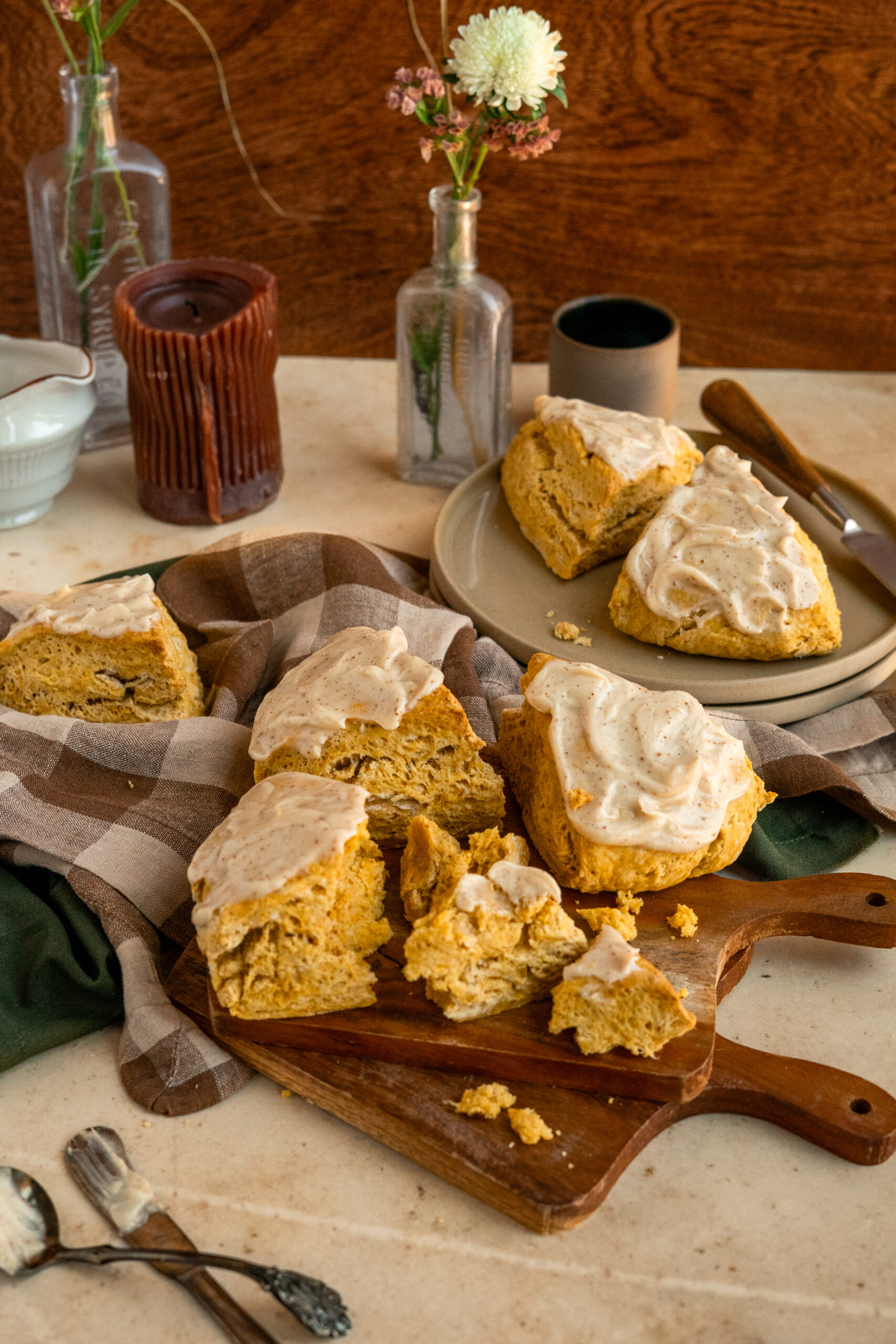 pumpkin scones on a wooden board with plaid napkins in the background.