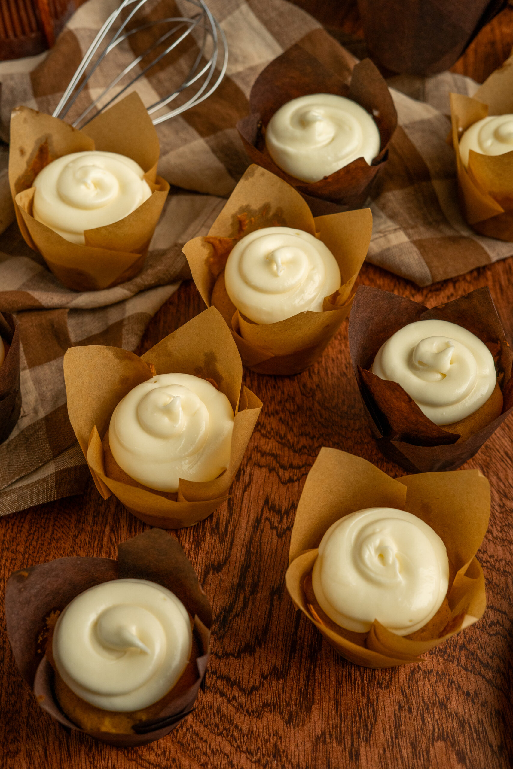 pumpkin spice cupcakes scattered on wooden background.