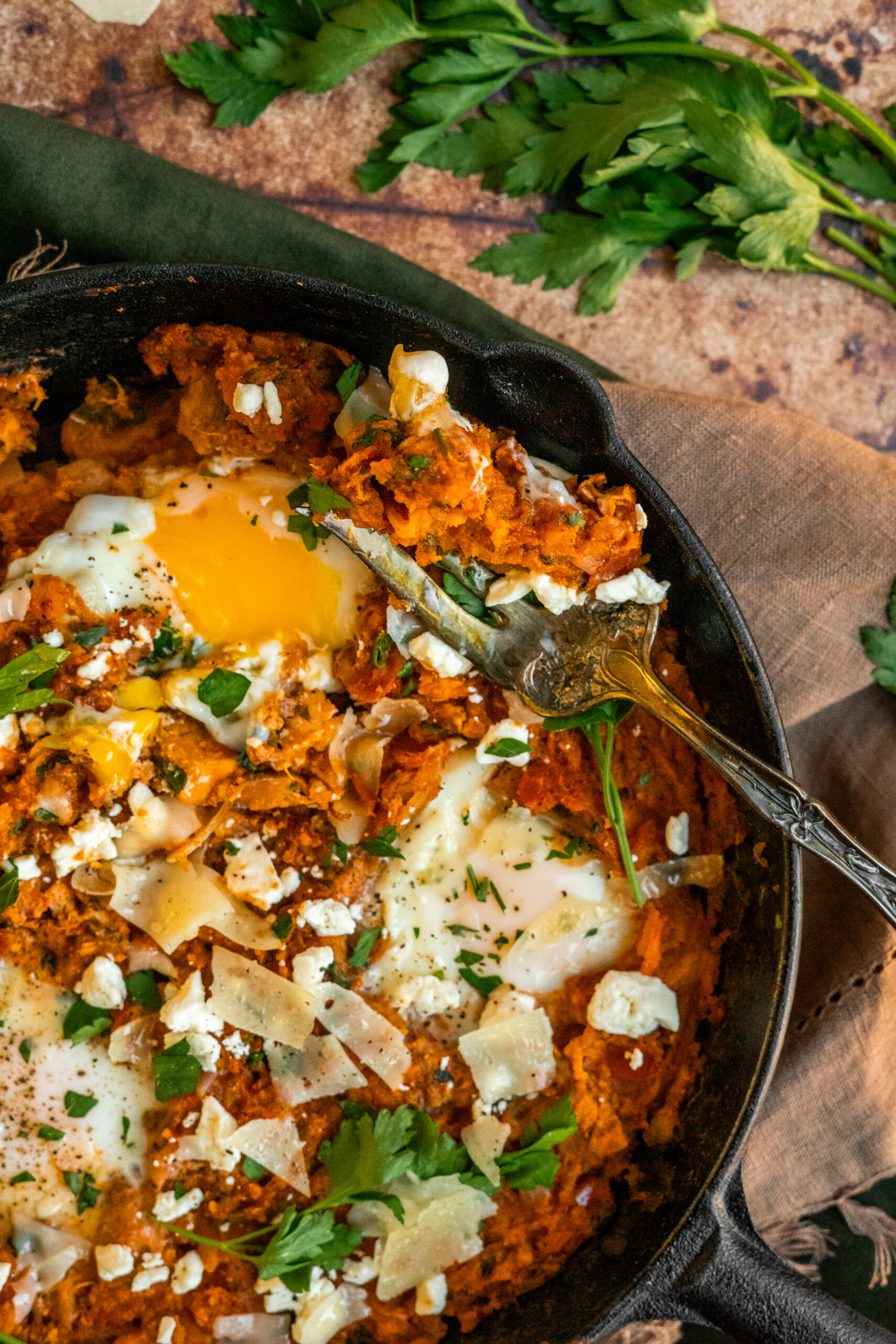 close up of shakshuka in skillet with forkful resting on the side of the pan.