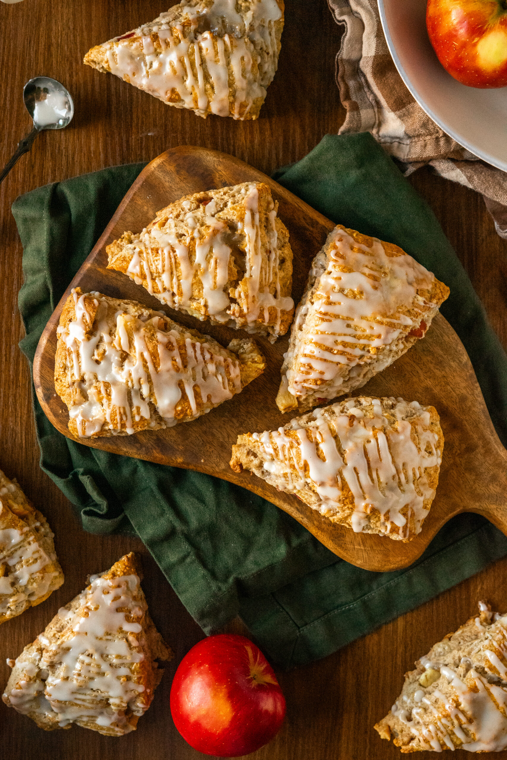 apple cider scones on wooden serving board on top of green napkin.