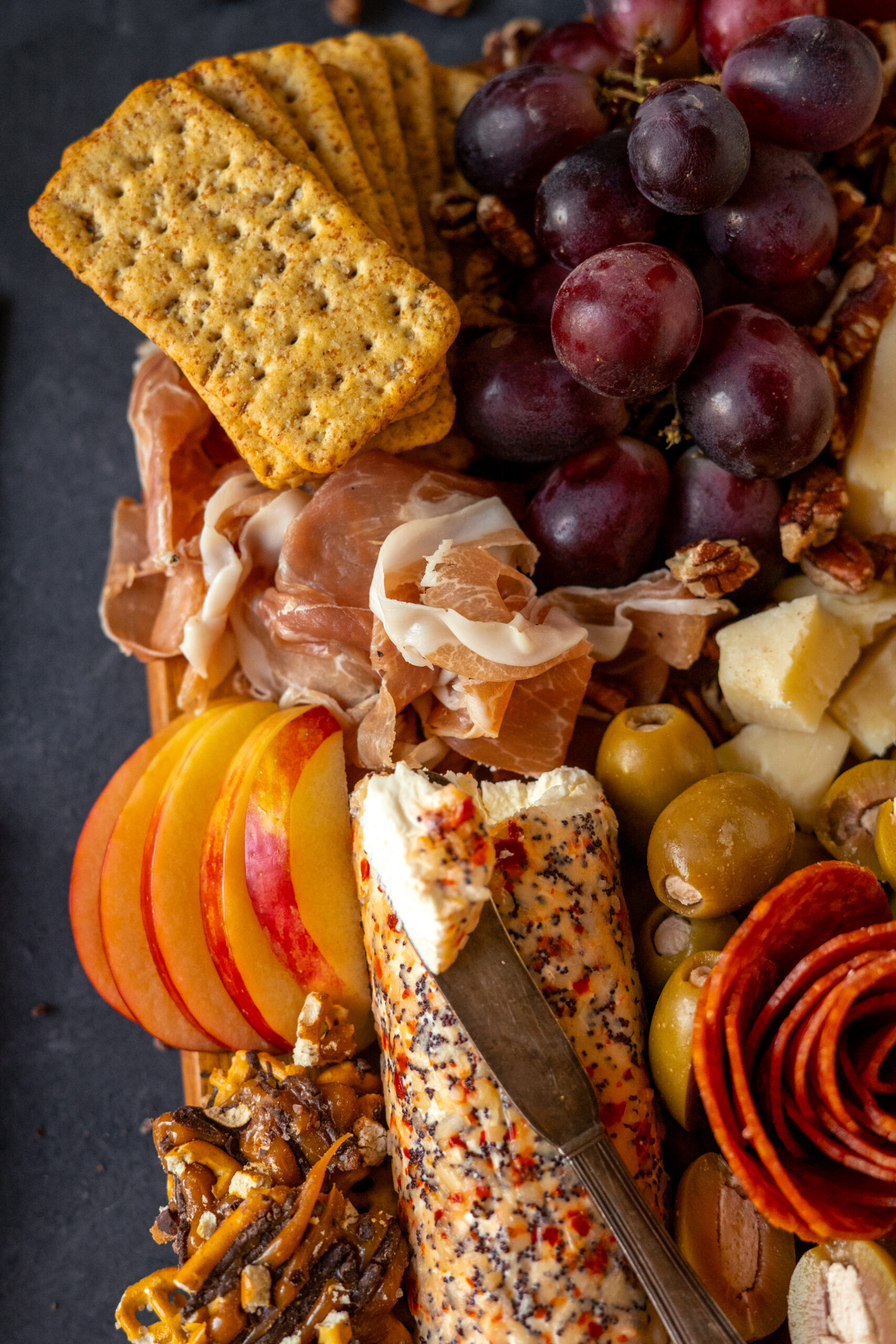 close up of crackers and grapes on charcuterie board.