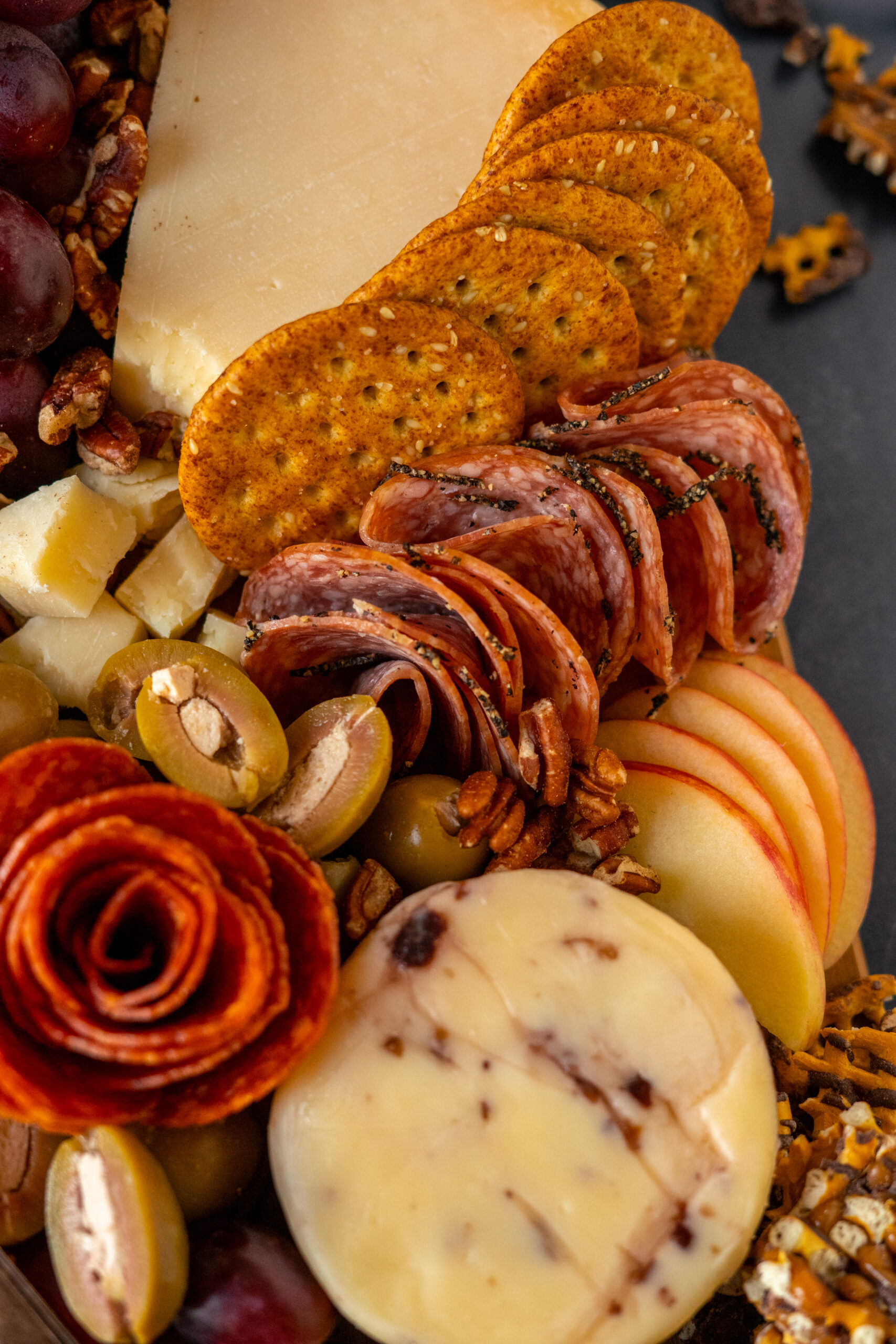 close up of meats and crackers on charcuterie board.