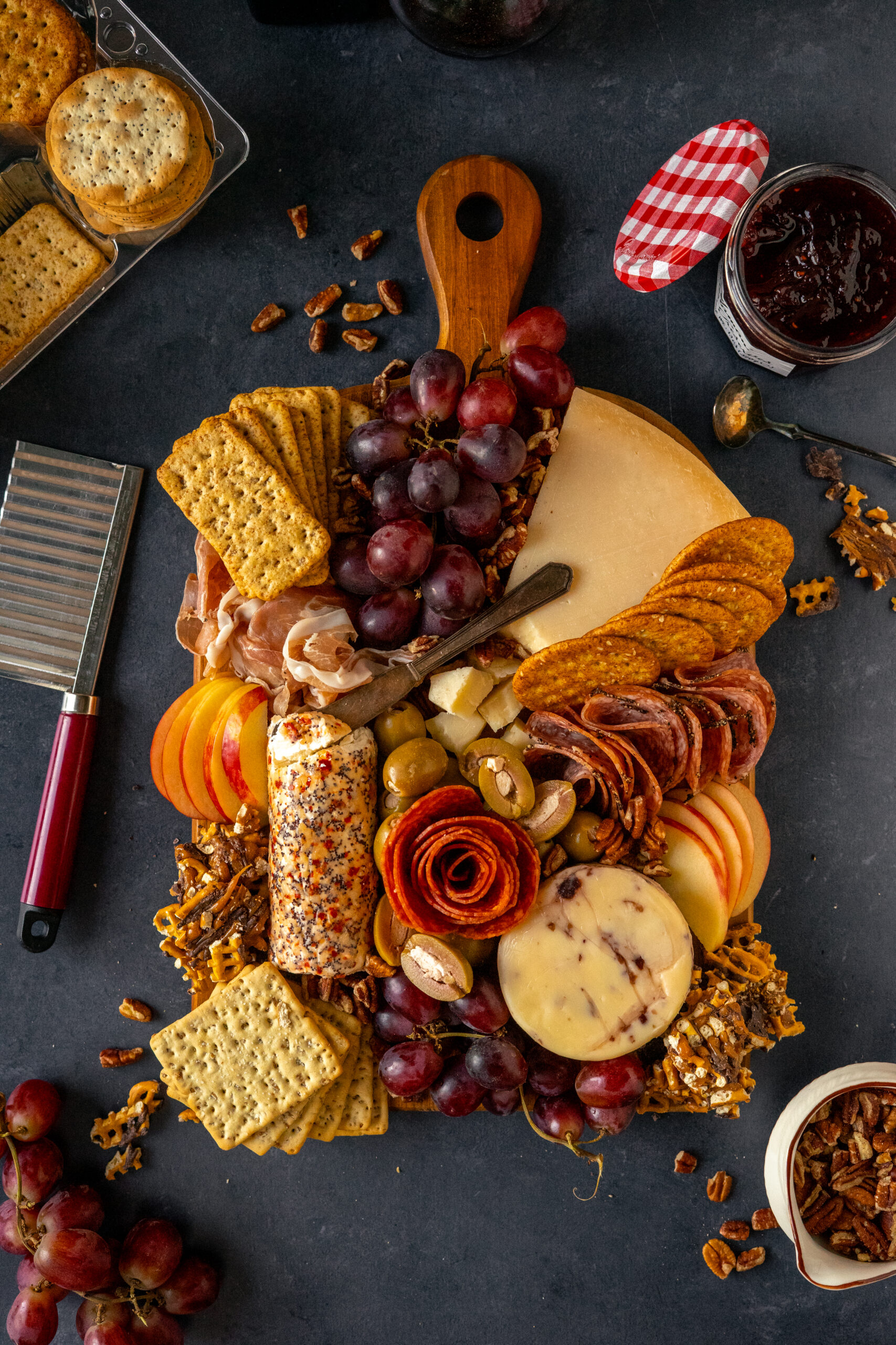 overhead view of full charcuterie board on dark surface.