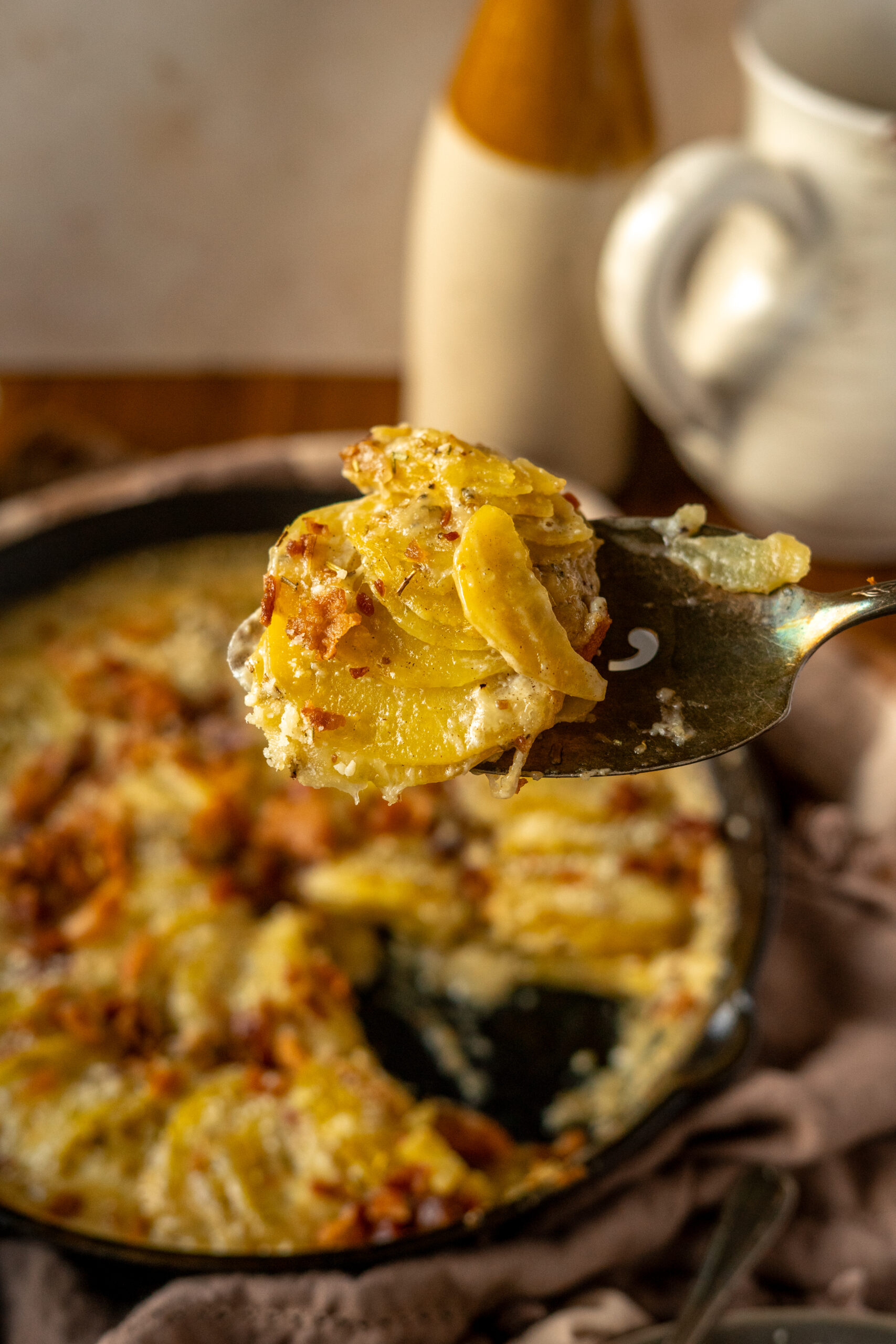 close up of a scoop of potatoes above the pan.