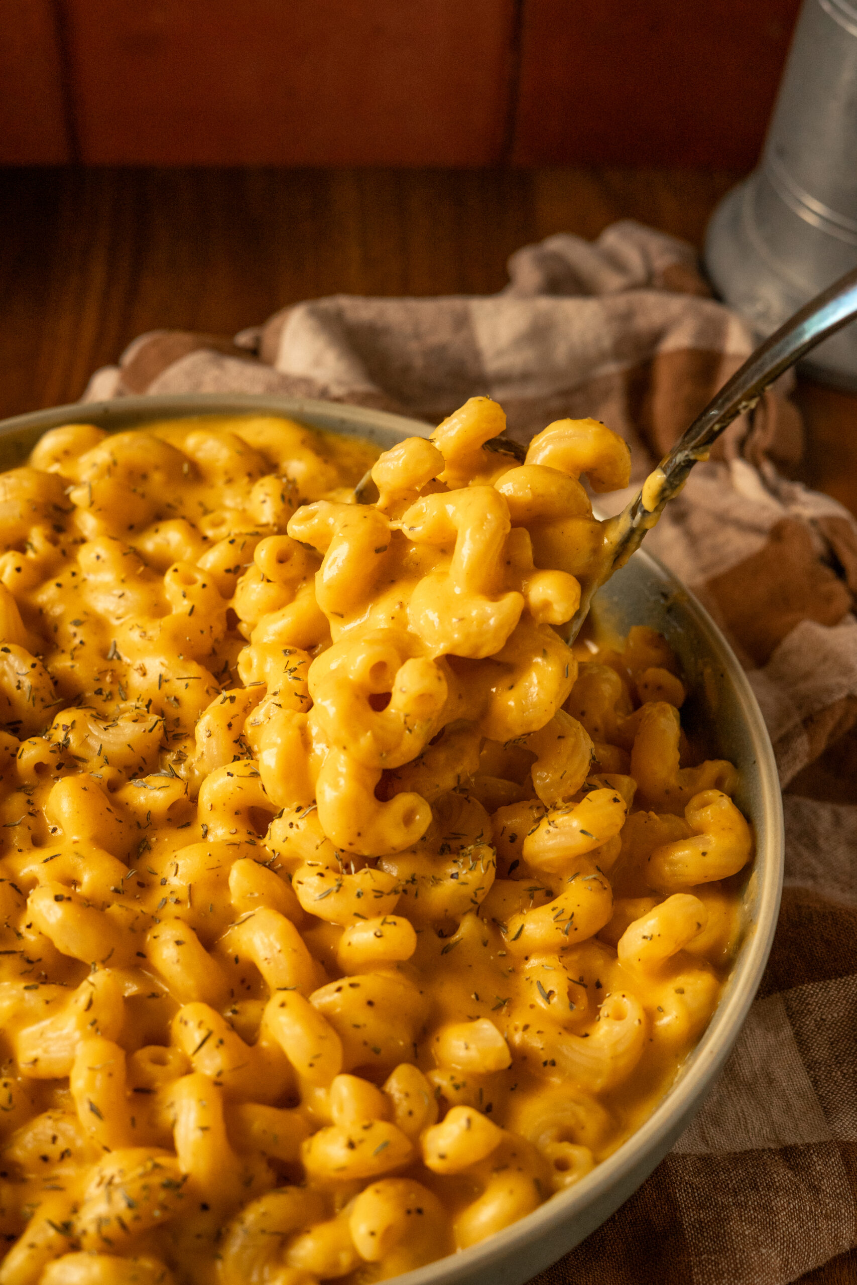 close up of a spoonful of mac and cheese being taken out of the bowl.