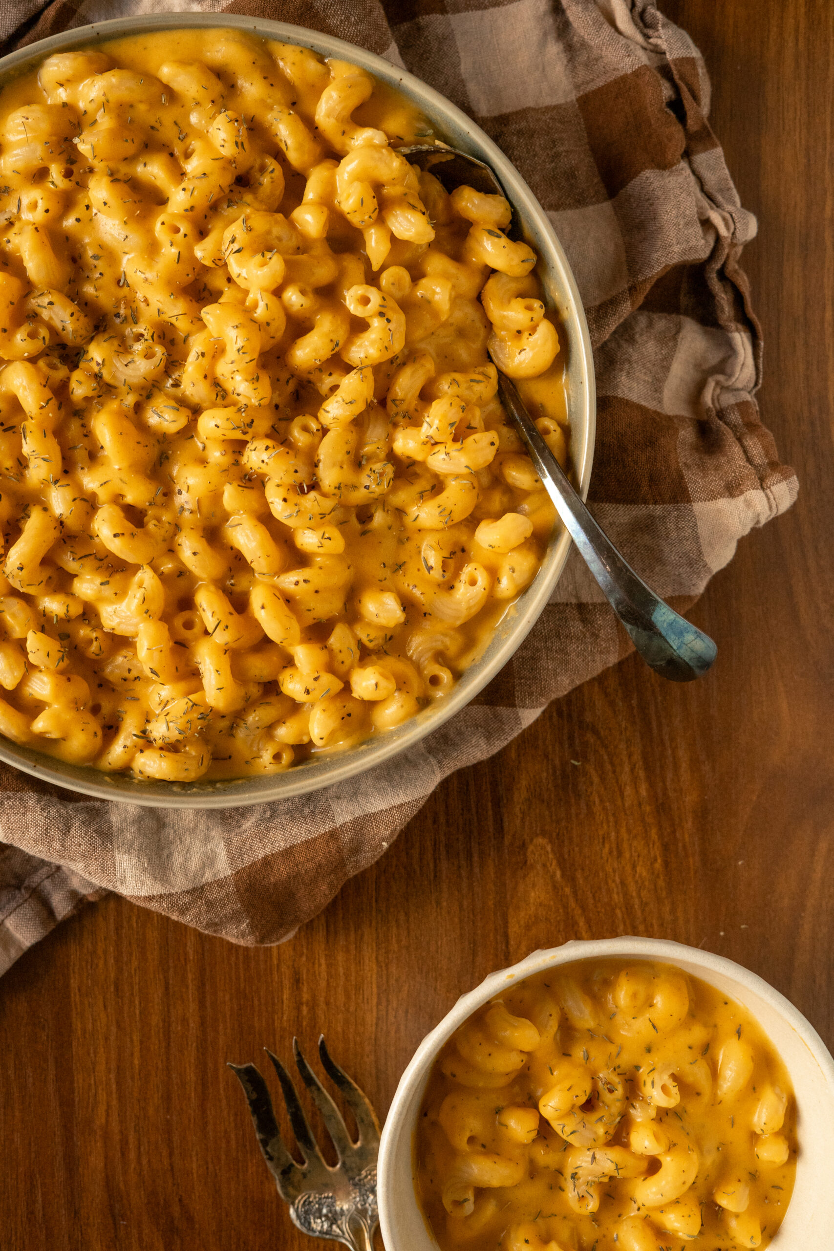 overhead view of mac and cheese in green bowl with a spoon resting on the bowl.