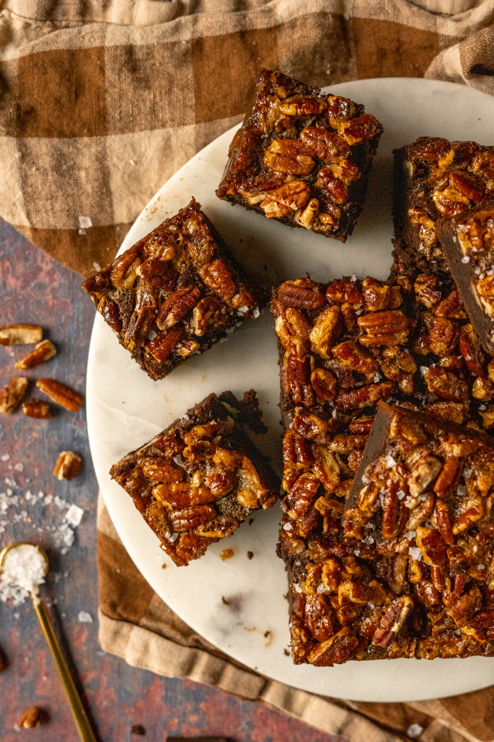 overhead view of pecan pie brownies scattered on marble slab.