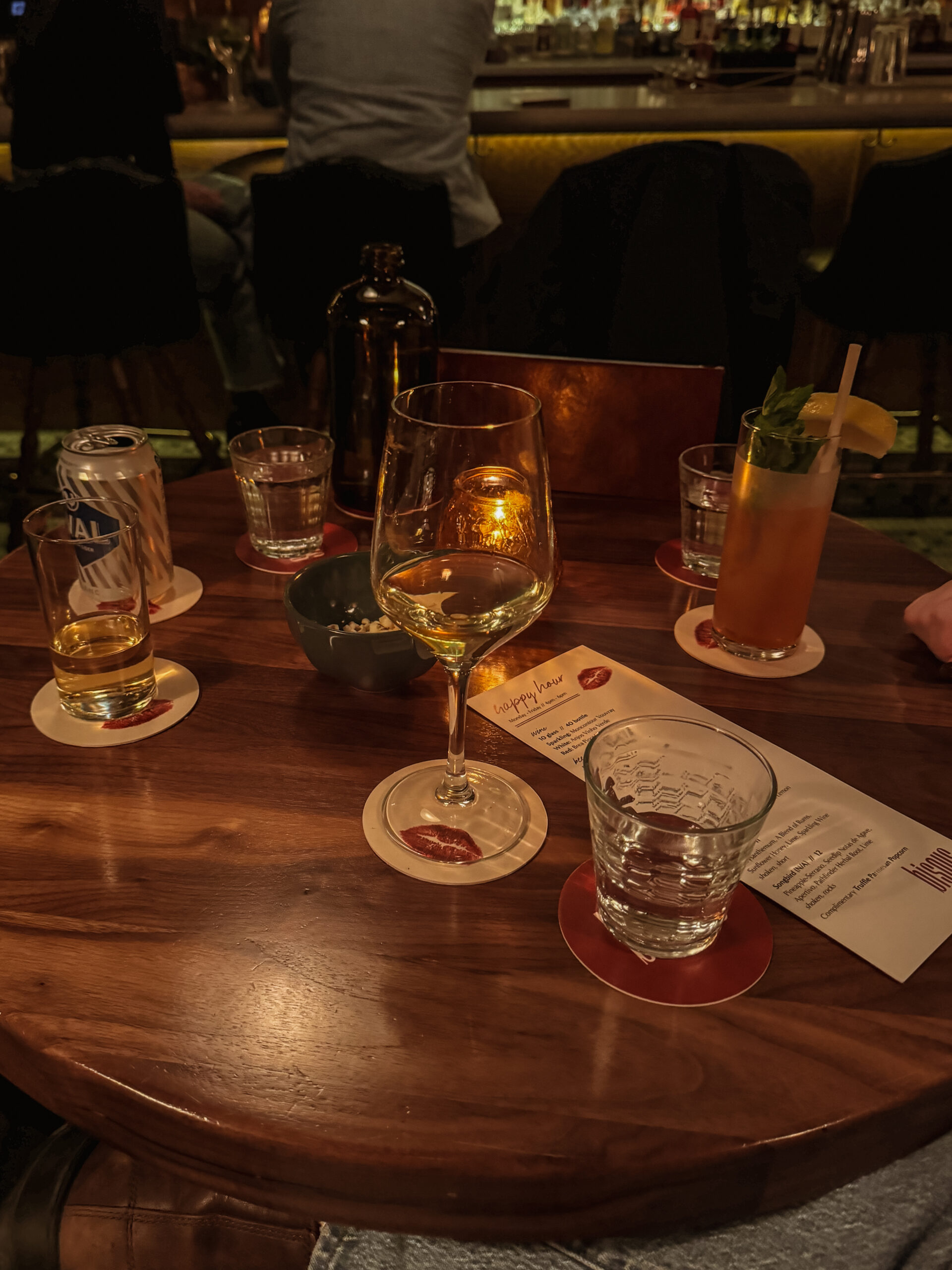 cocktail and wine glasses on dark wooden table.