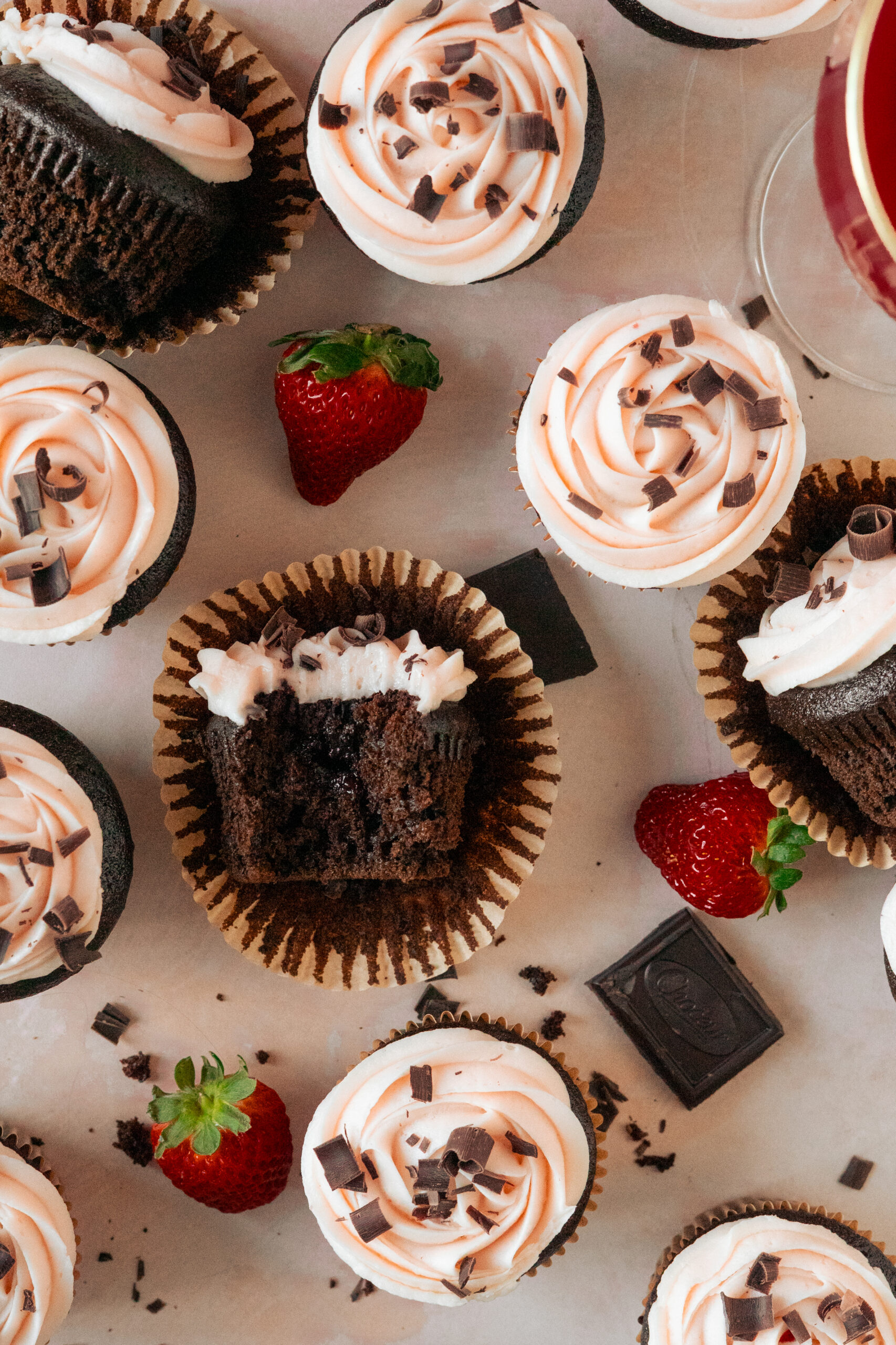 overhead view of chocolate strawberry cupcakes with bite taken out of one.