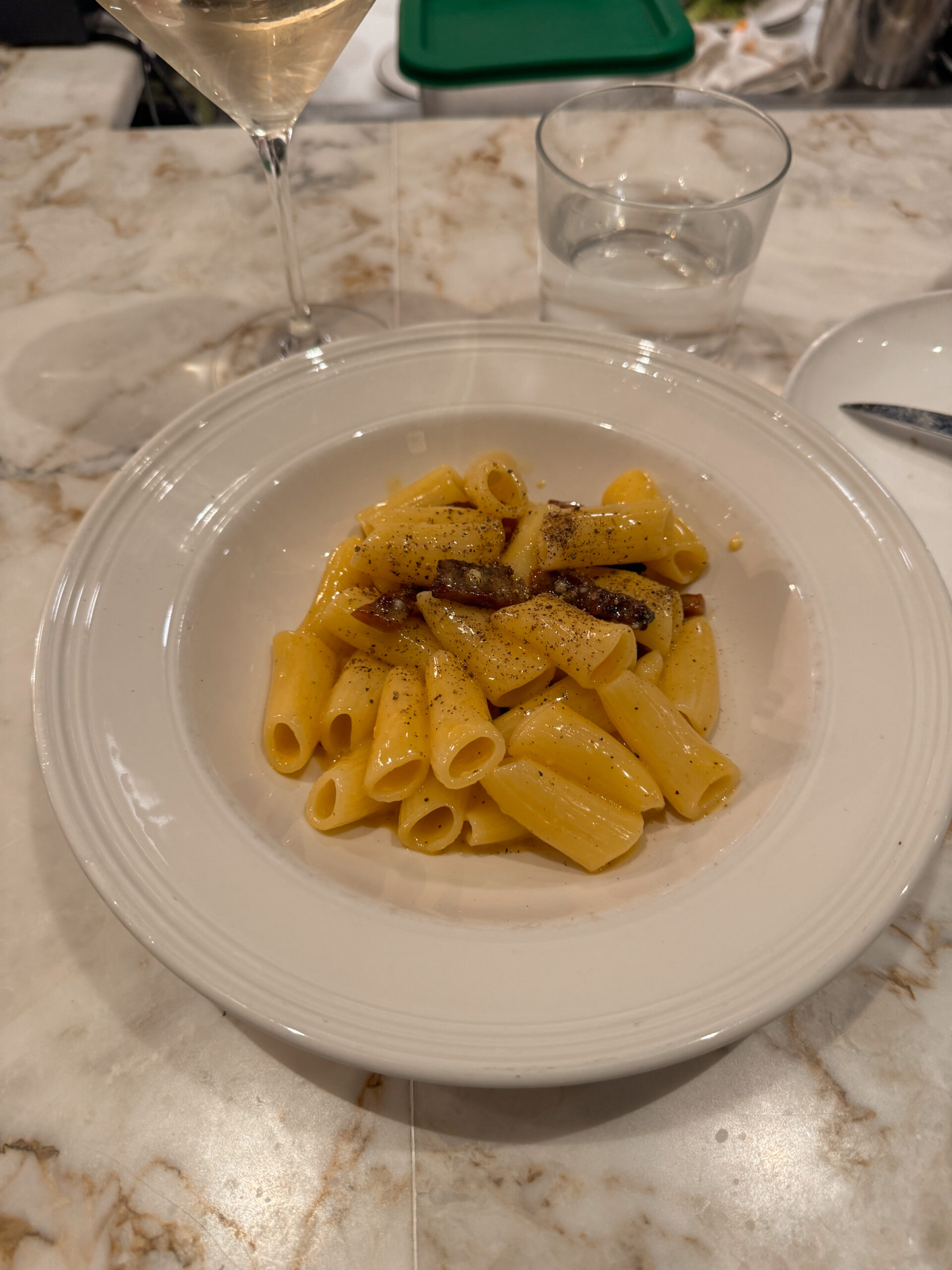 rigatoni carbonara on white plate.
