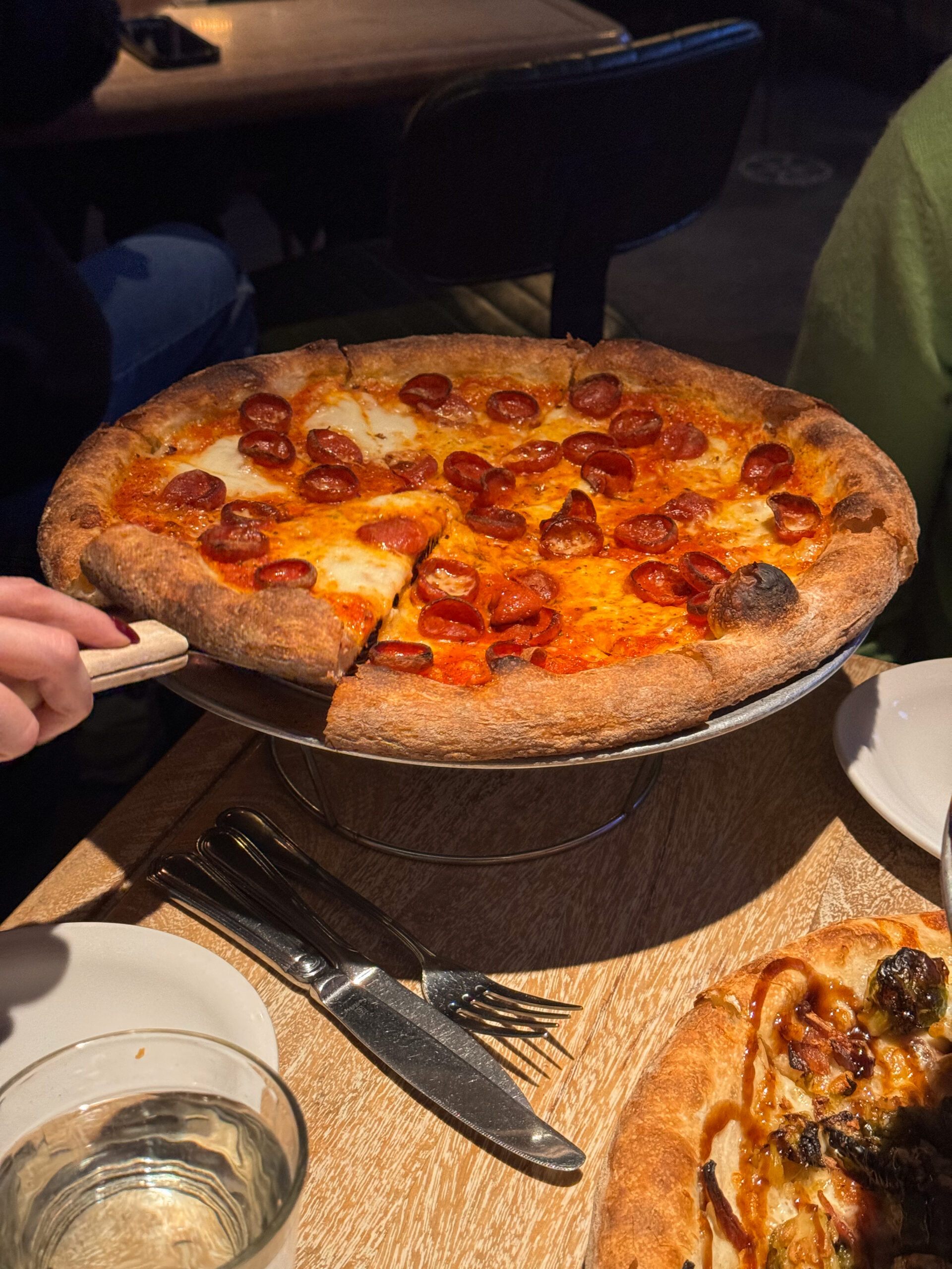 pepperoni pizza with slice being taken.