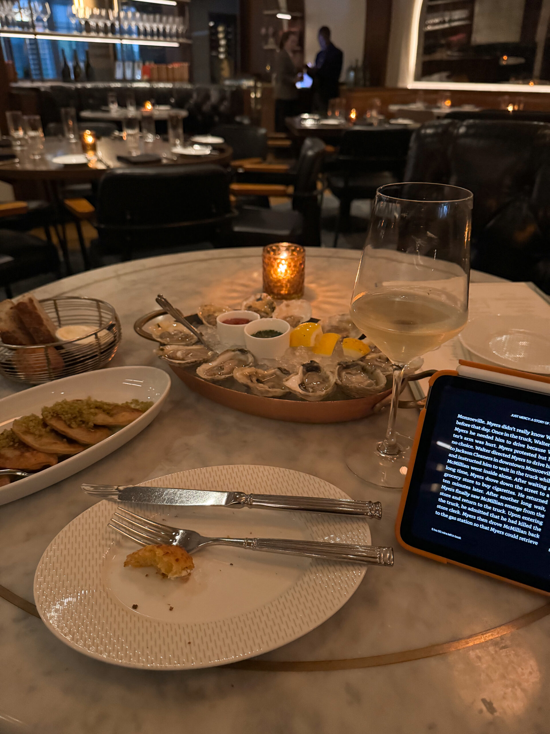 dining table with oysters, pierogi, and wine.