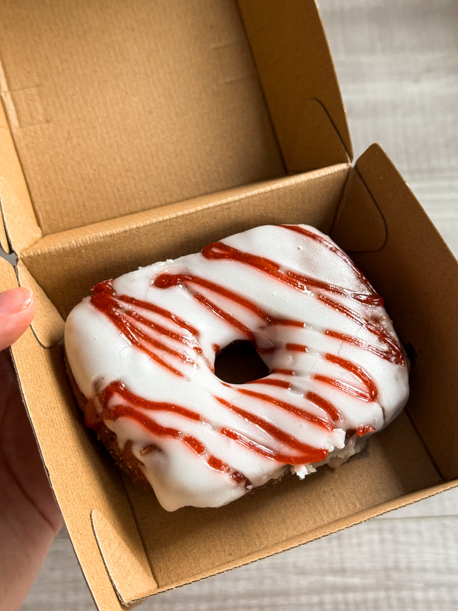 strawberry donut in takeout container.