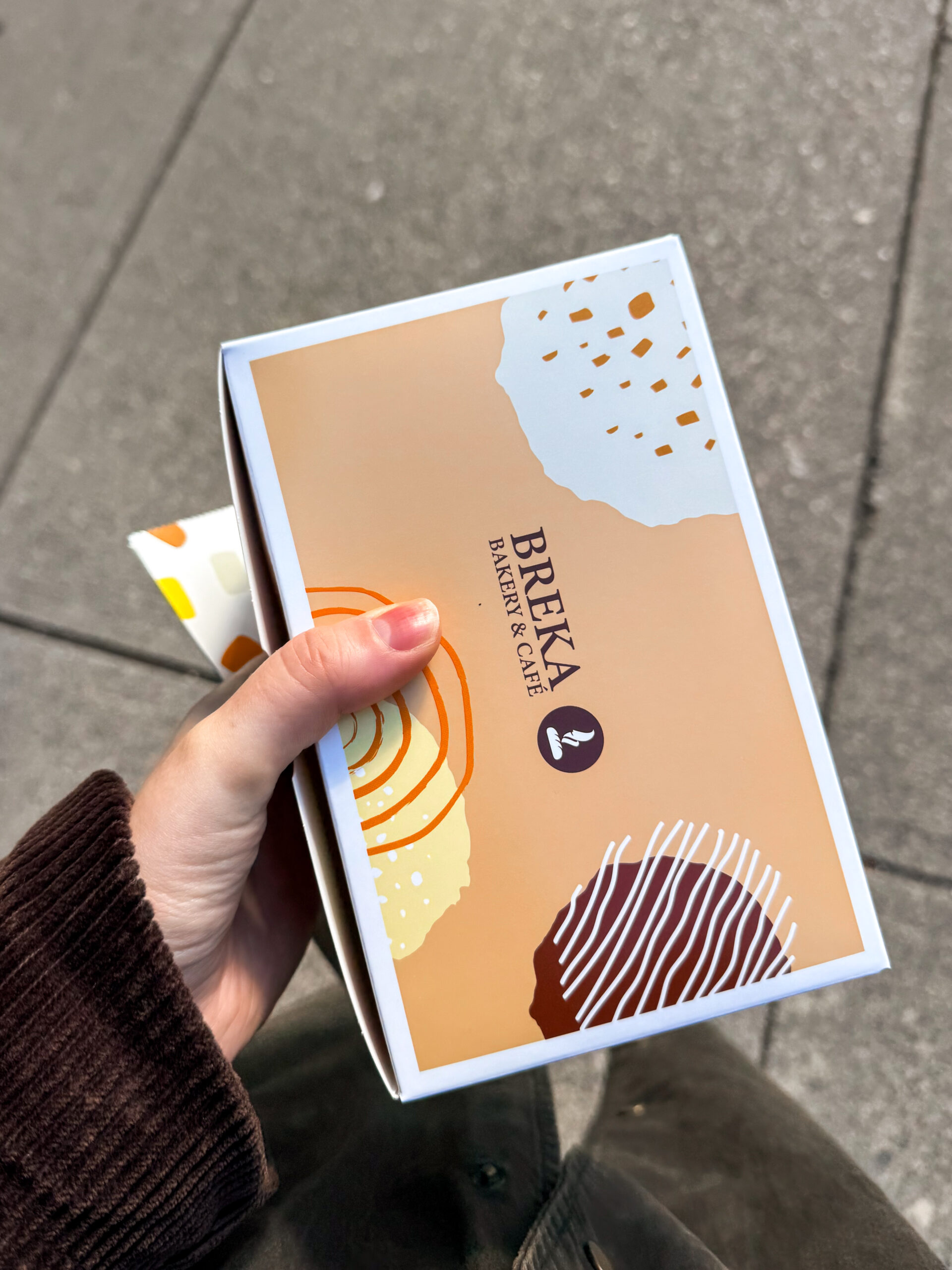 bakery box held on sidewalk.